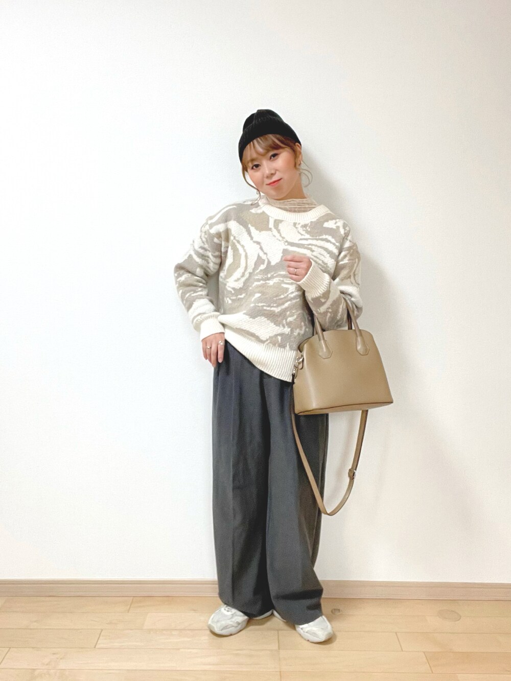 ベージュ系のニット/セーター、ホワイト系のトップス、グレー系のパンツを着用したレディースの冬コーディネートの4枚目の写真
