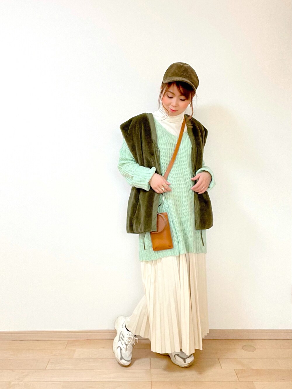 ホワイト系のTシャツ/カットソー、グリーン系のニット/セーター、ホワイト系のスカートを着用したレディースの冬コーディネートの2枚目の写真
