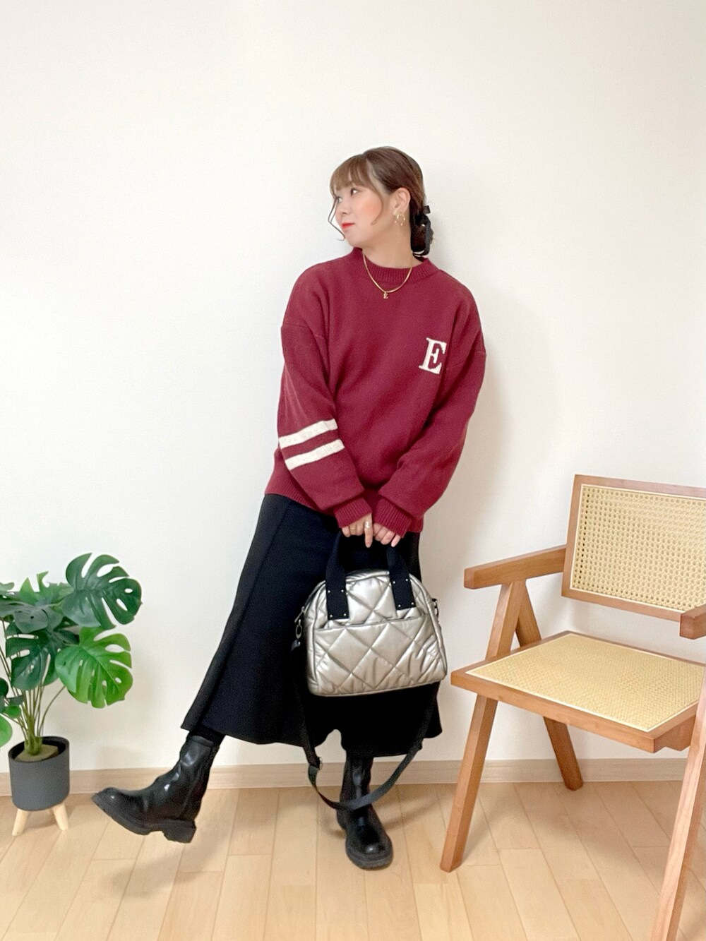 レッド系のニット/セーター、ブラック系のスカート、シルバー系のトートバッグを着用したレディースの冬コーディネートの3枚目の写真