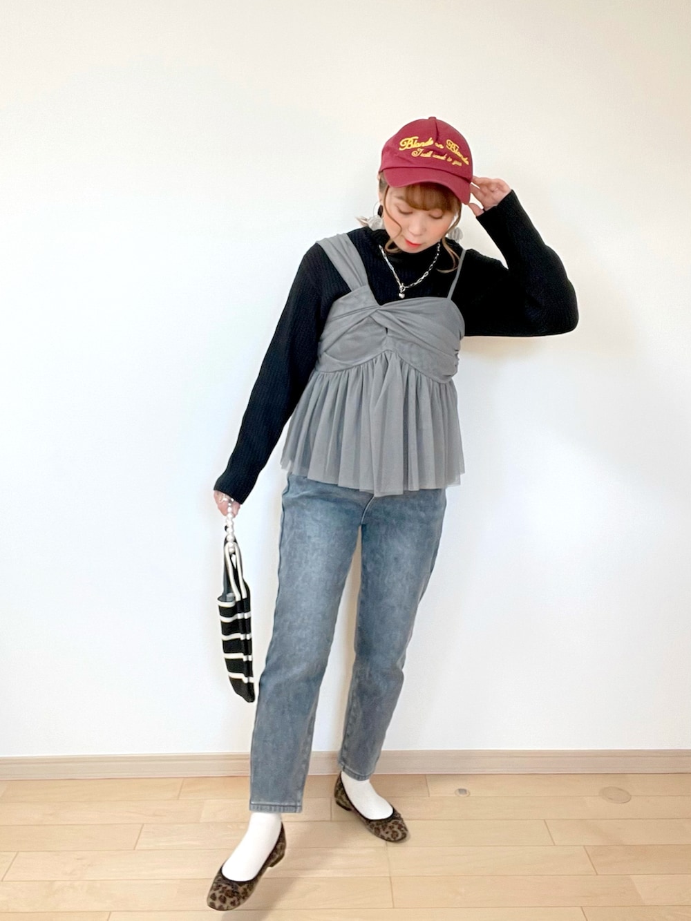 グレー系のキャミソール、ホワイト系のニット/セーター、グレー系のデニムパンツを着用したレディースの冬コーディネートの3枚目の写真