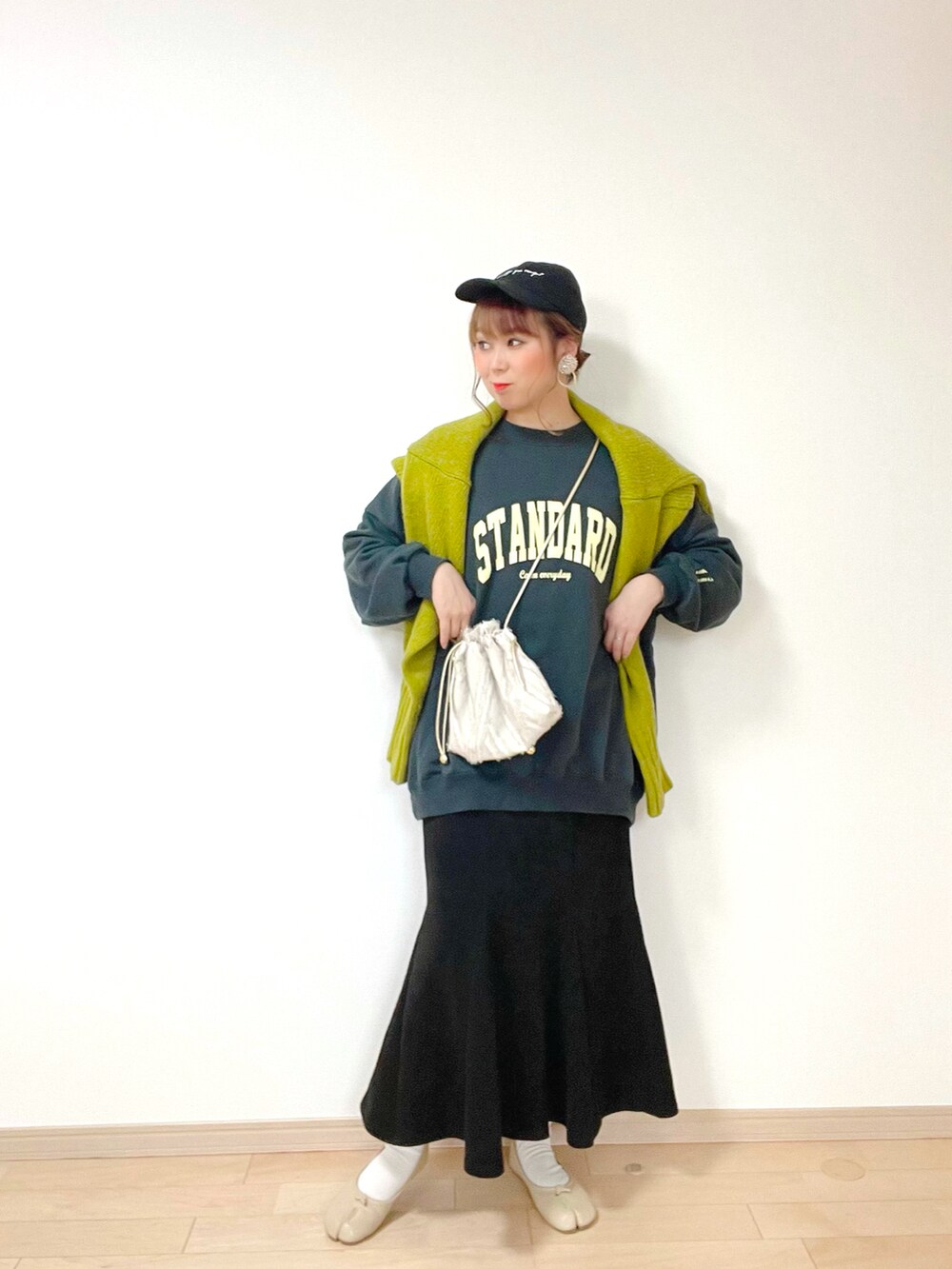 ブラック系のスウェット、グリーン系のニット/セーター、ブラック系のスカートを着用したレディースの冬コーディネートの3枚目の写真