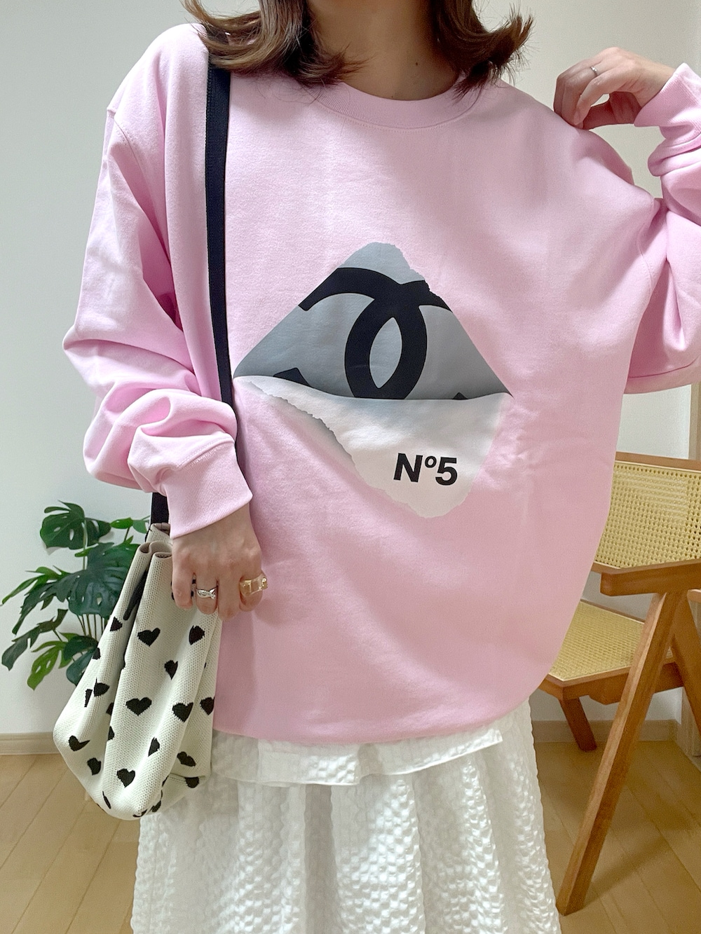 ピンク系のスウェット、ホワイト系のショルダーバッグ、グレー系のシューズを着用したレディースの冬コーディネートの3枚目の写真