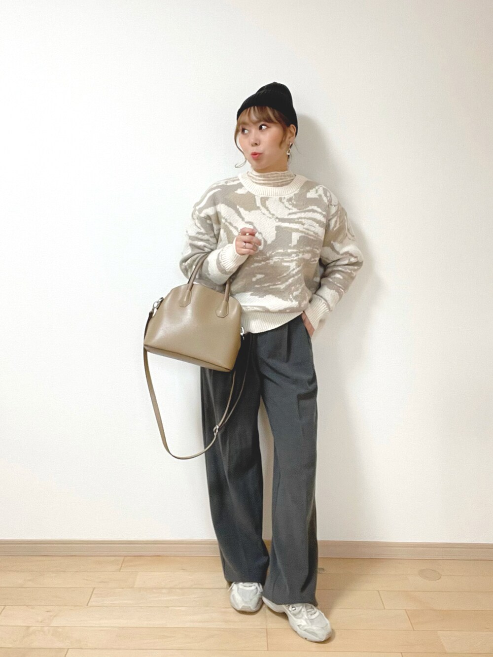 ベージュ系のニット/セーター、ホワイト系のトップス、グレー系のパンツを着用したレディースの冬コーディネートの2枚目の写真