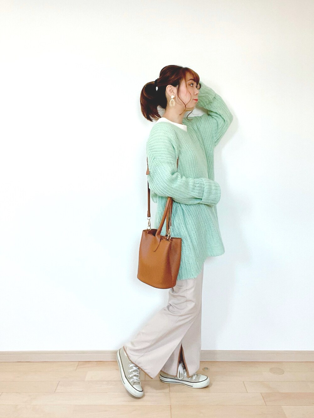 グリーン系のニット/セーター、ホワイト系のTシャツ/カットソー、ベージュ系のその他パンツを着用したレディースの冬コーディネートの2枚目の写真