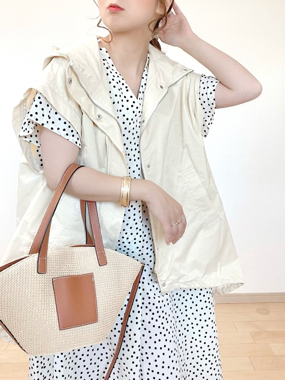 ホワイト系のブルゾン、ベージュ系のタンクトップ、ホワイト系のワンピースを着用したレディースの春コーディネートの5枚目の写真