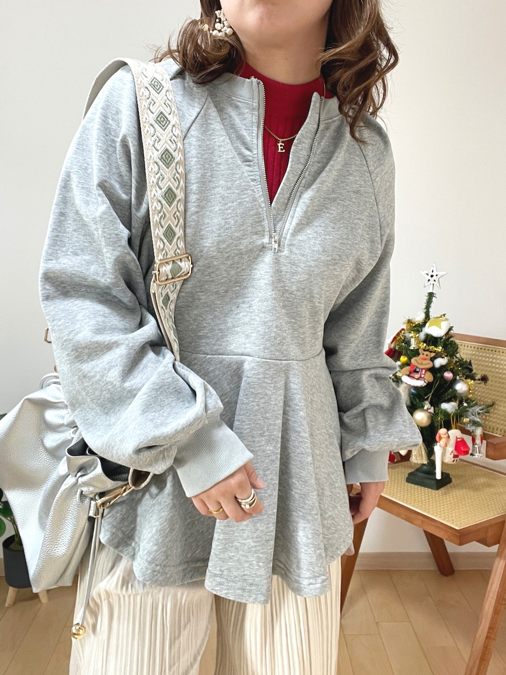 グレー系のスウェット、レッド系のニット/セーター、ホワイト系のその他パンツを着用したレディースの冬コーディネートの3枚目の写真