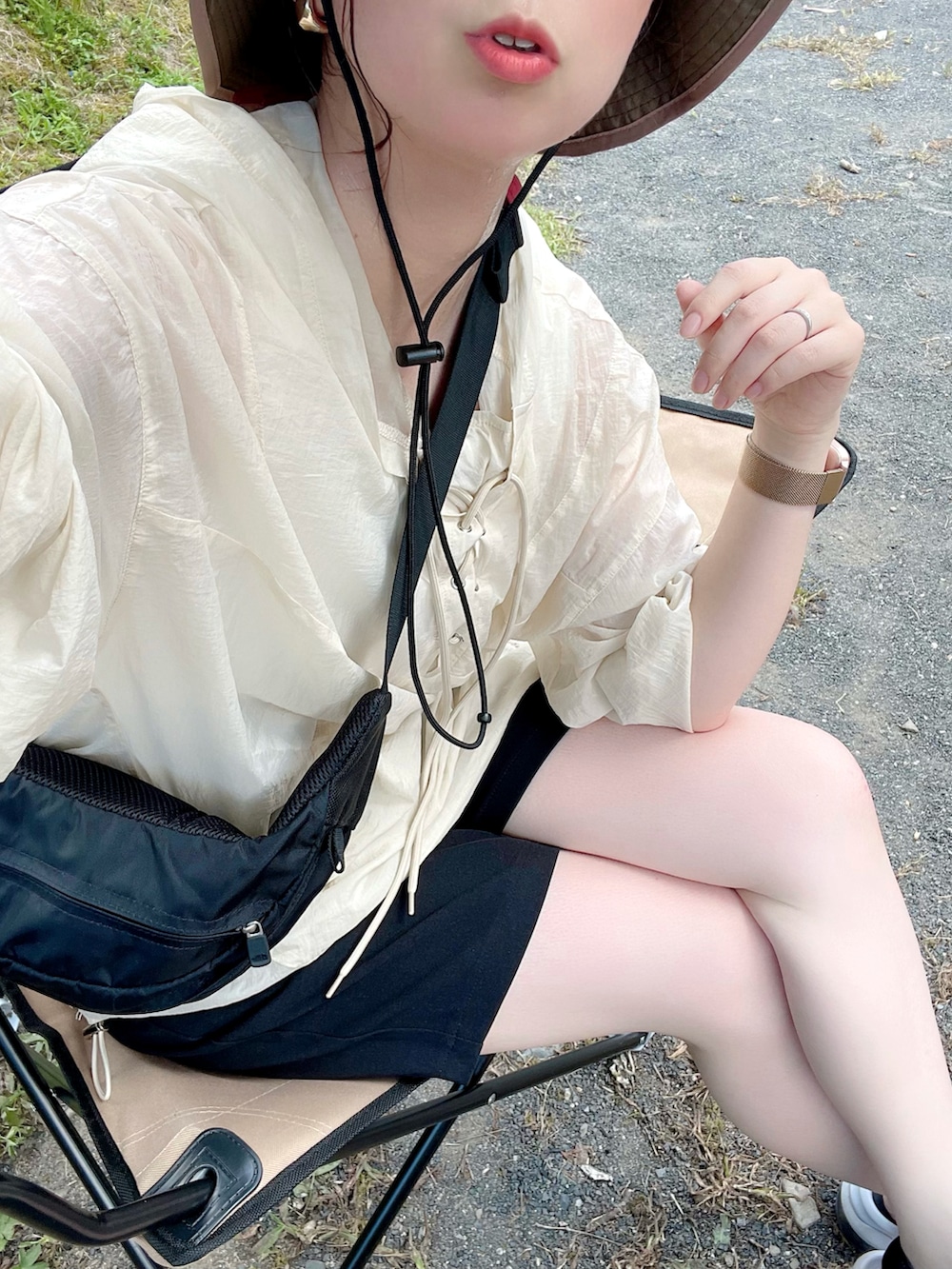 ベージュ系のトップス、ブラック系のパンツ、ブラック系のサンダルを着用したレディースの夏コーディネートの5枚目の写真