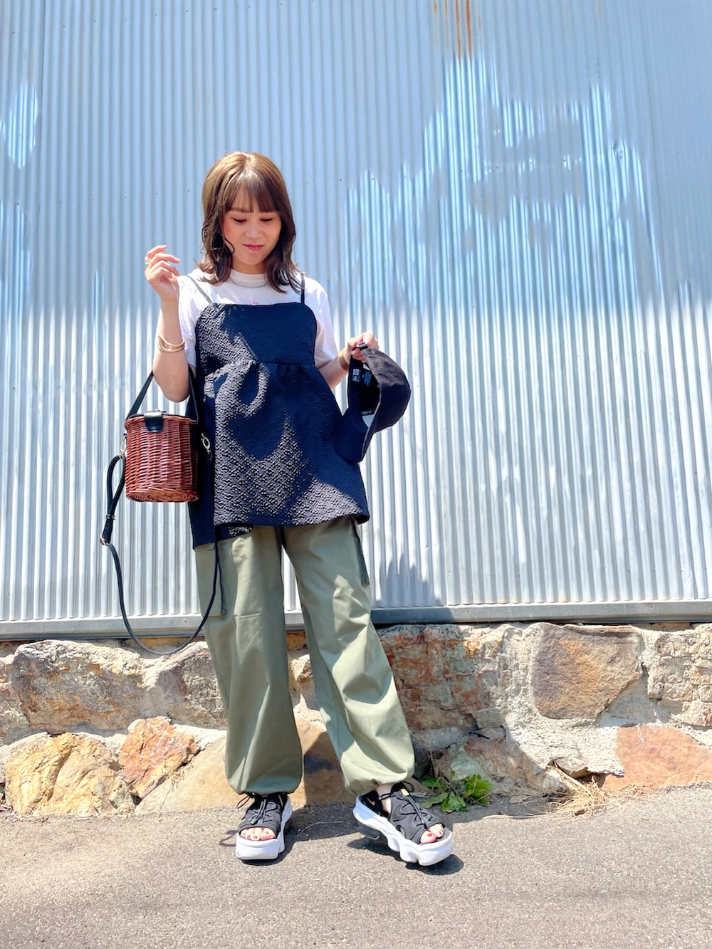 ホワイト系のTシャツ/カットソー、ブラック系のキャミソール、グリーン系のカーゴパンツを着用したレディースの春コーディネートの2枚目の写真