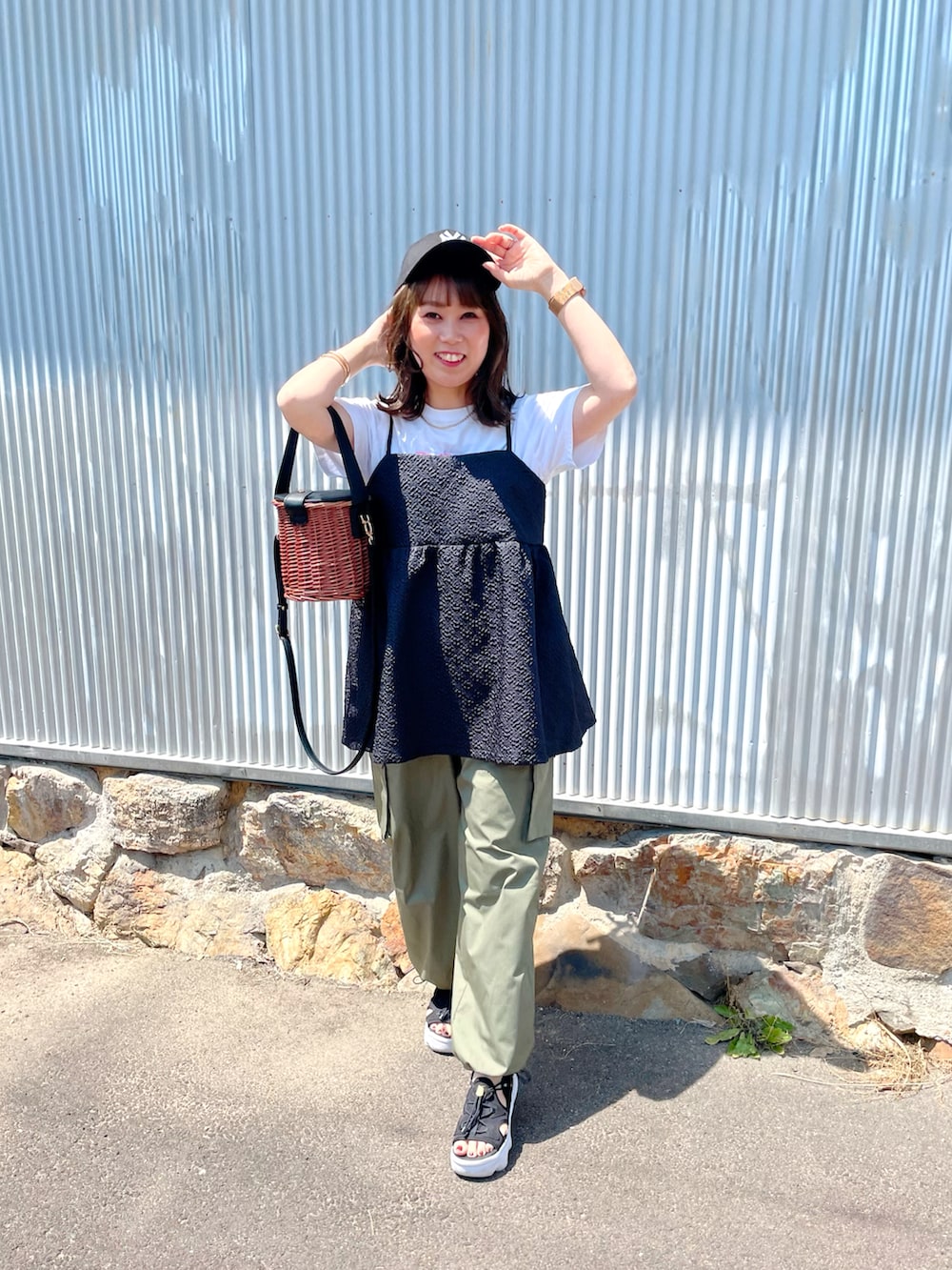 ホワイト系のTシャツ/カットソー、ブラック系のキャミソール、グリーン系のカーゴパンツを着用したレディースの春コーディネートの4枚目の写真