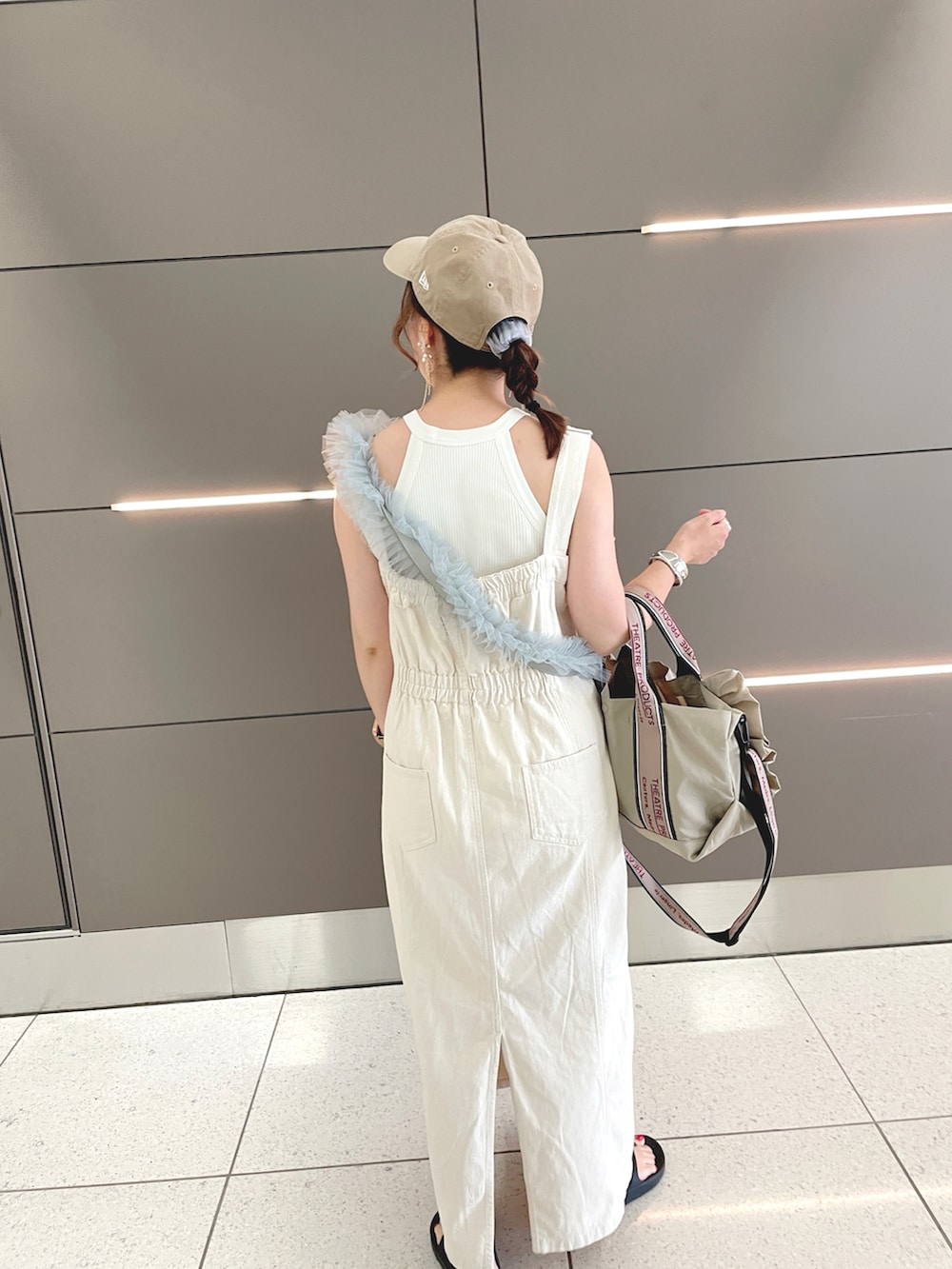 ブラック系のベスト、ホワイト系のタンクトップ、ベージュ系のジャンパースカートを着用したレディースの夏コーディネートの4枚目の写真