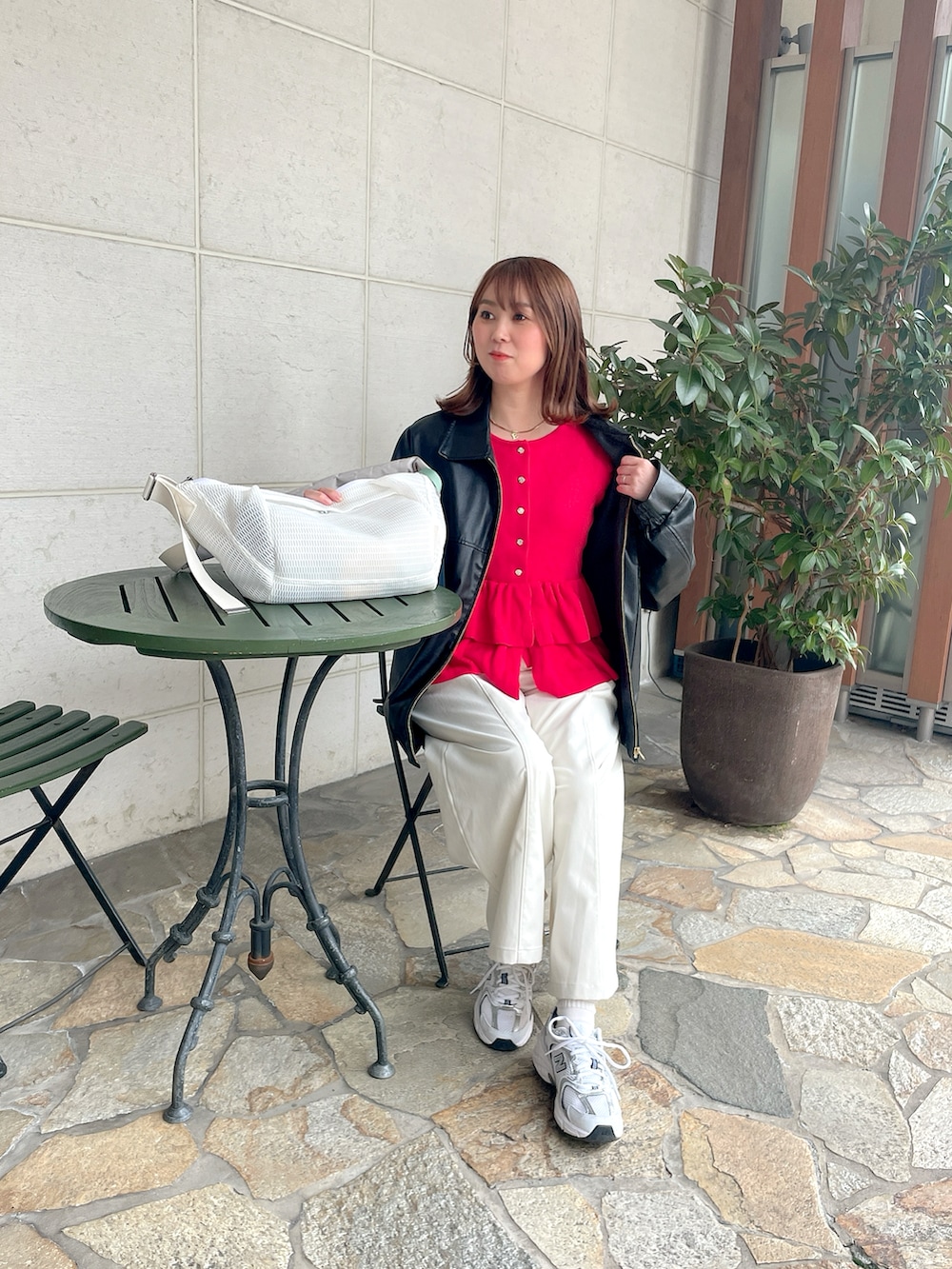 ホワイト系のボディバッグ/ウエストポーチ、ブラック系のブルゾン、レッド系のニット/セーターを着用したレディースの春コーディネートの2枚目の写真