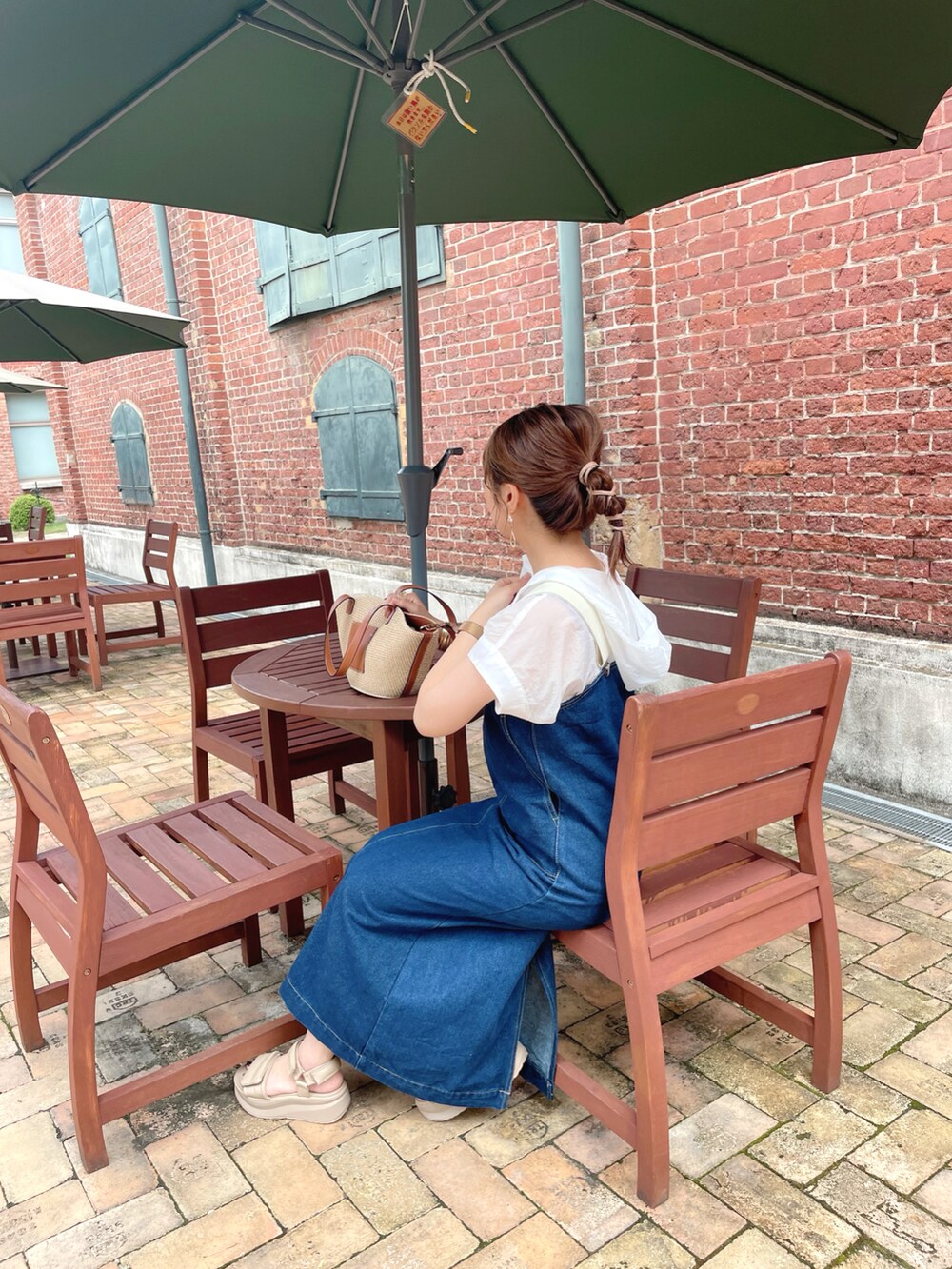 ホワイト系のトップス、ブルー系のオールインワン・サロペット、ブラウン系のタンクトップを着用したレディースの夏コーディネートの4枚目の写真