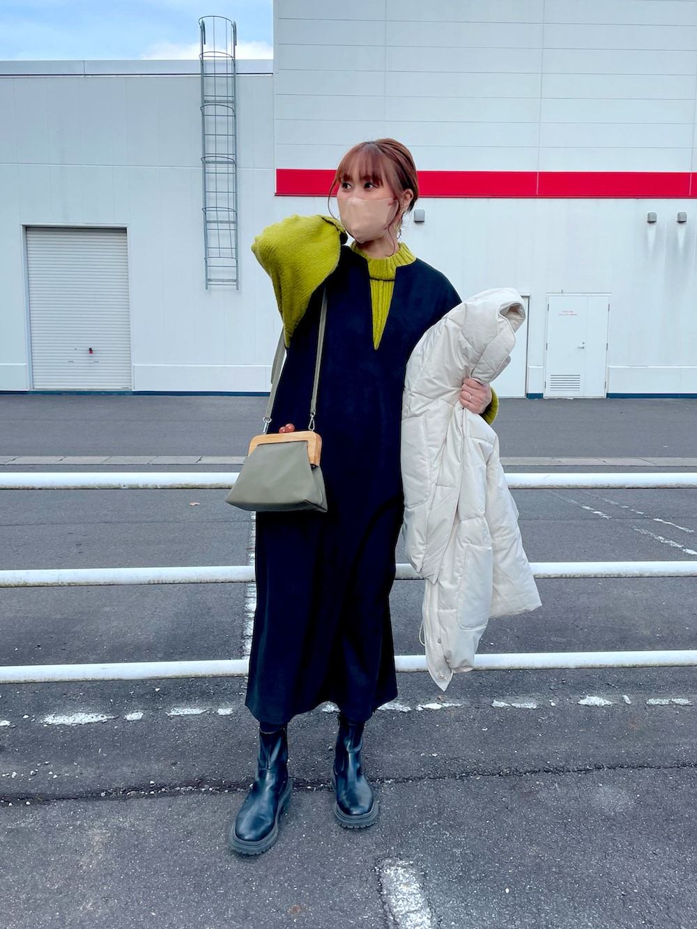 ホワイト系のジャケット/アウター、グリーン系のニット/セーター、ブラック系のワンピース/ドレスを着用したレディースの冬コーディネートの2枚目の写真