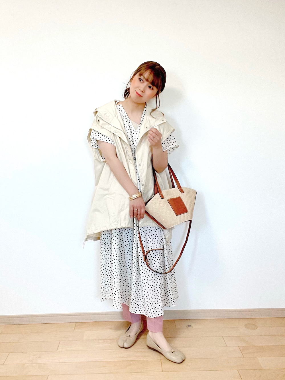 ホワイト系のブルゾン、ベージュ系のタンクトップ、ホワイト系のワンピースを着用したレディースの春コーディネートの3枚目の写真