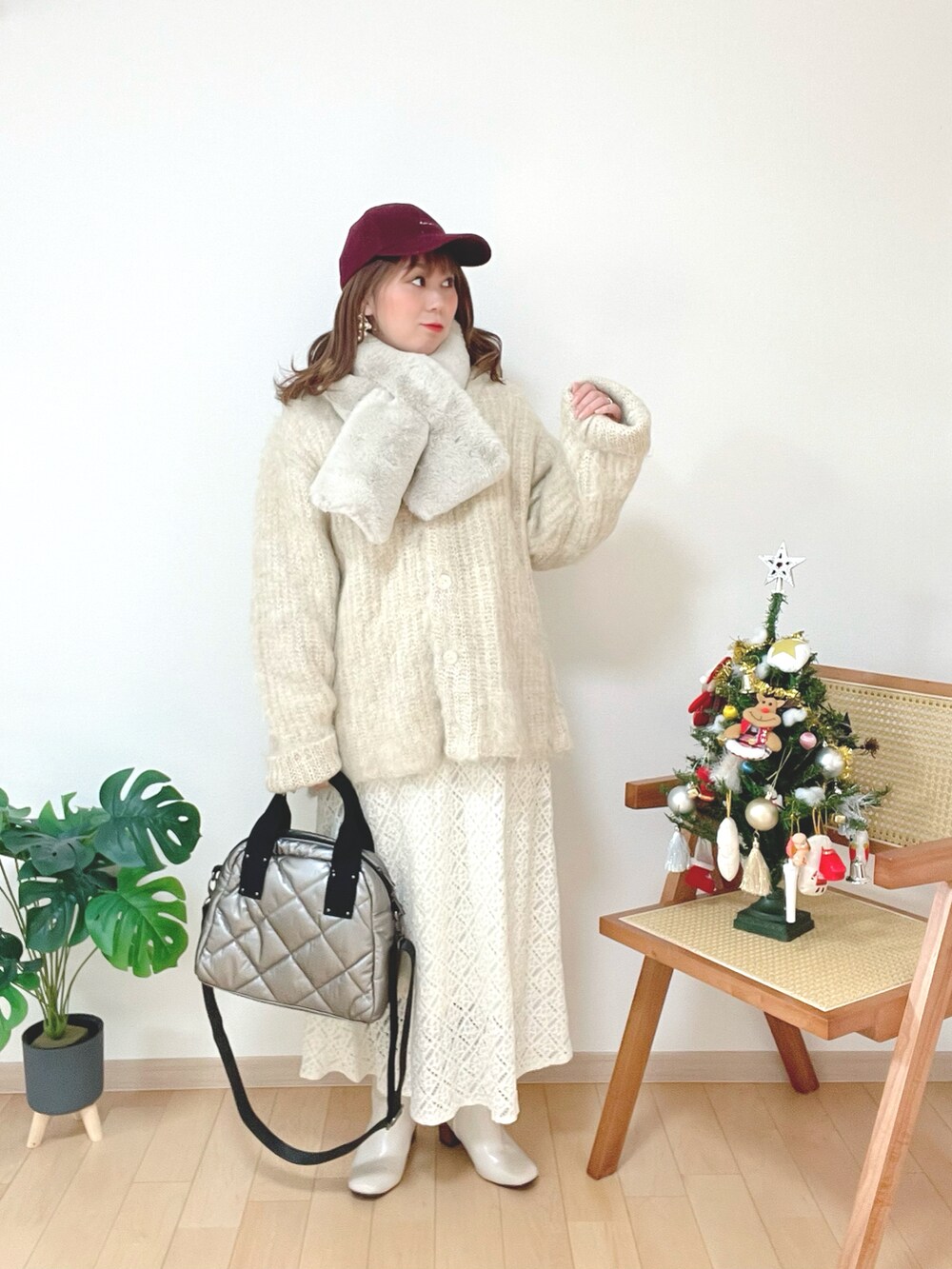 ベージュ系のカーディガン/ボレロ、ホワイト系のスカート、ホワイト系のブーツを着用したレディースの冬コーディネートの2枚目の写真