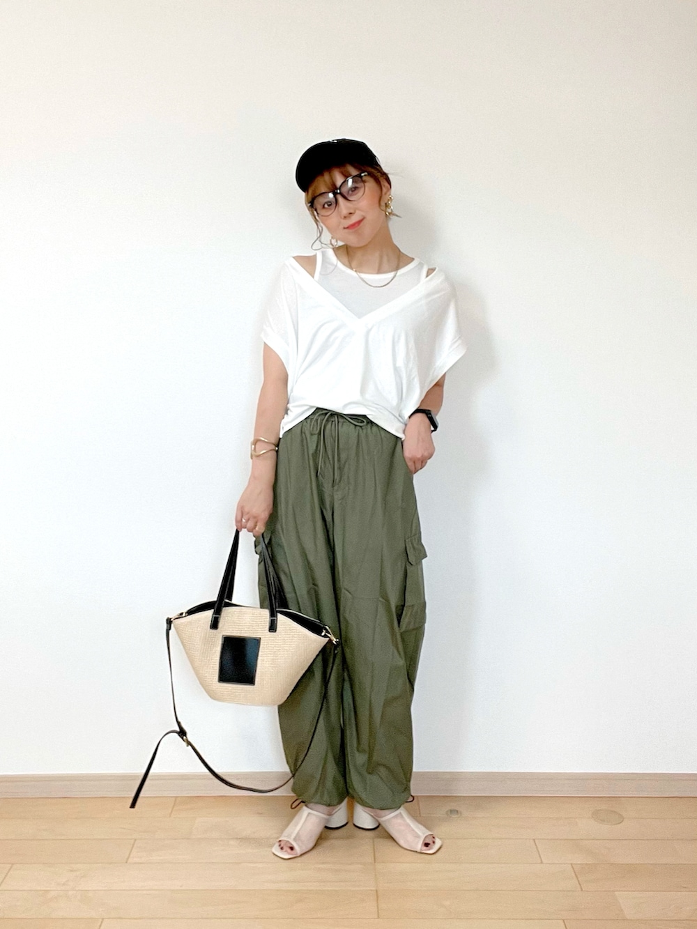 ホワイト系のトップス、グリーン系のカーゴパンツ、ベージュ系のサンダルを着用したレディースの夏コーディネートの4枚目の写真