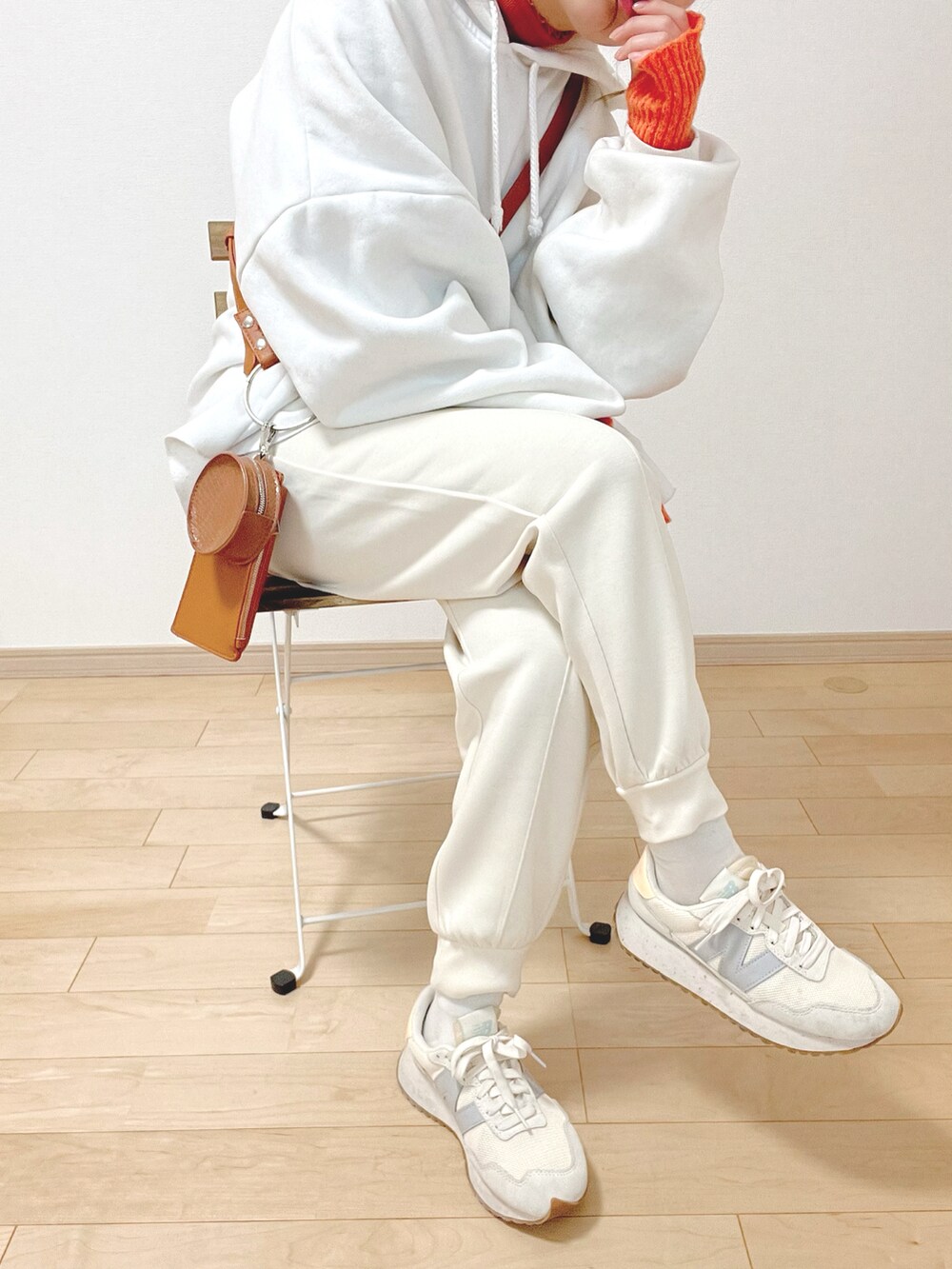ホワイト系のスウェットパンツ、ホワイト系のパーカー、オレンジ系のトップスを着用したレディースの冬コーディネートの2枚目の写真