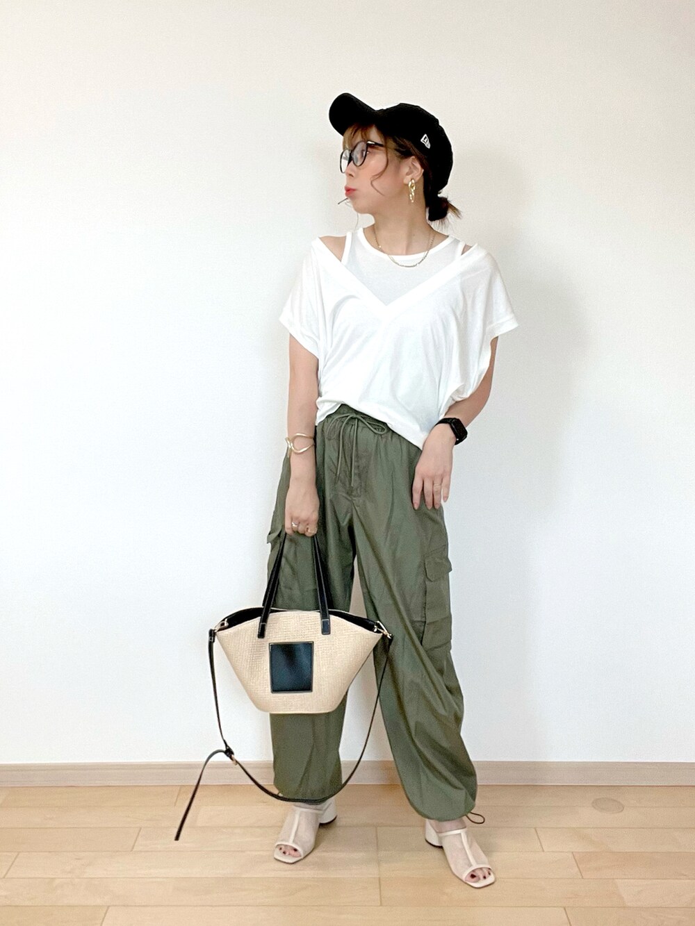 ホワイト系のトップス、グリーン系のカーゴパンツ、ベージュ系のサンダルを着用したレディースの夏コーディネートの3枚目の写真