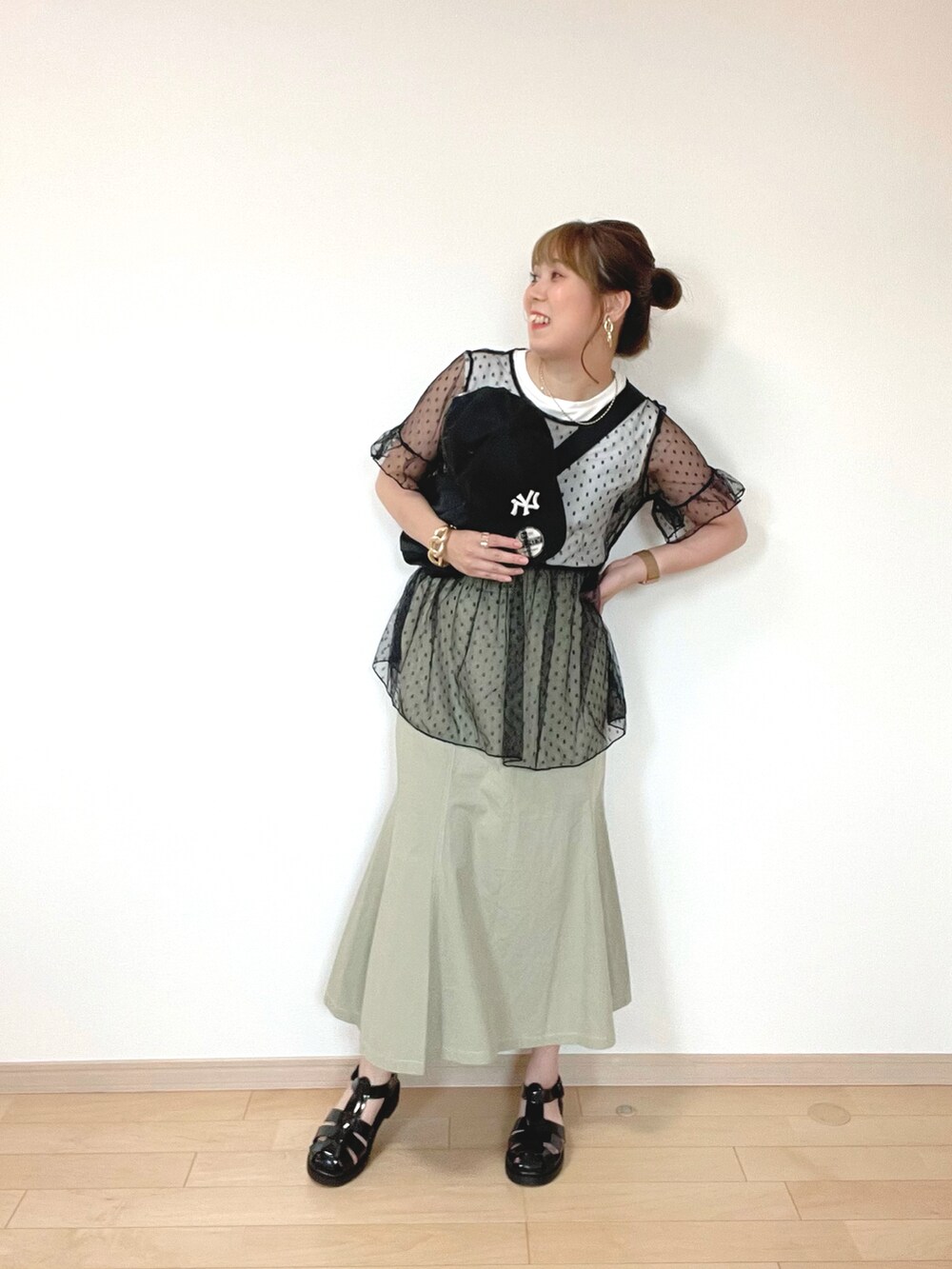 ホワイト系のTシャツ/カットソー、ブラック系のトップス、グリーン系のスカートを着用したレディースの夏コーディネートの3枚目の写真