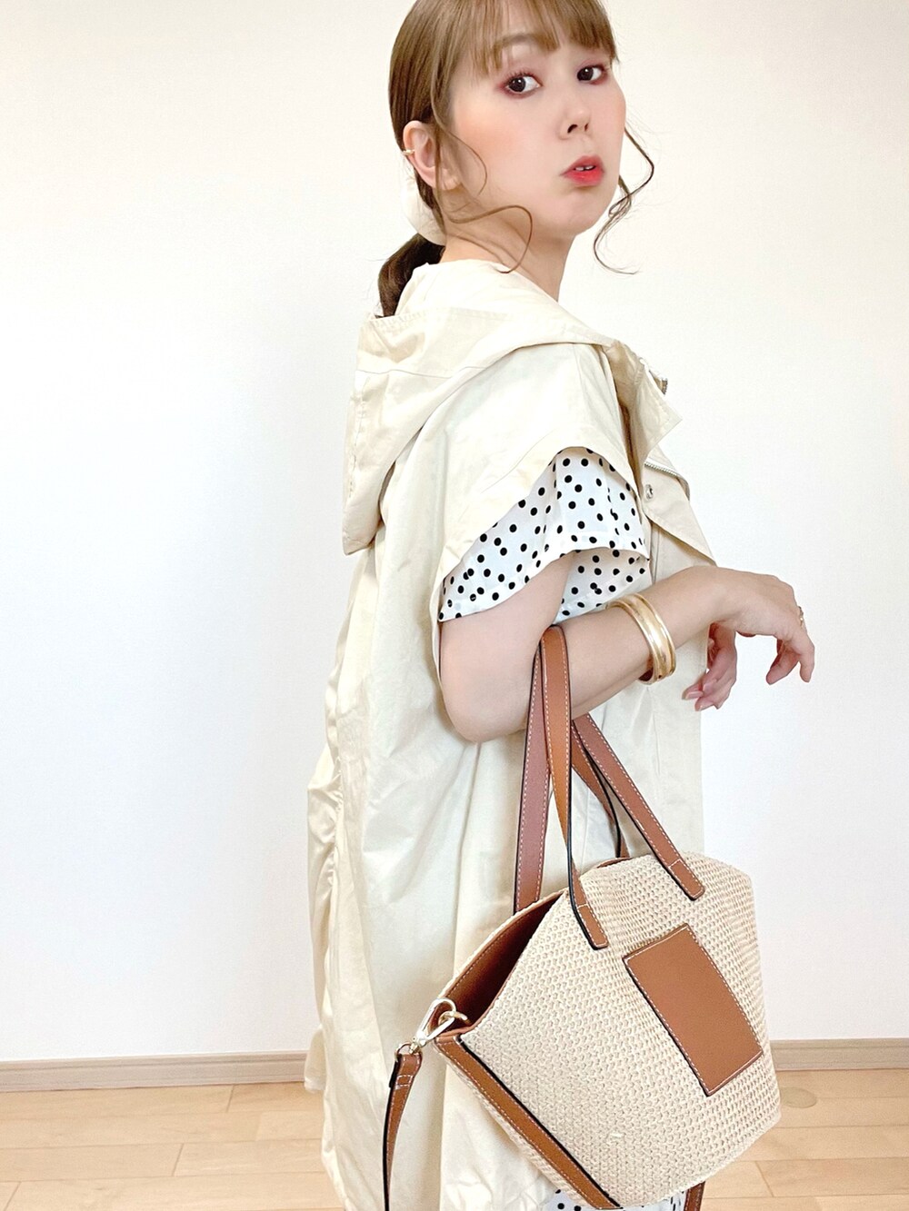 ホワイト系のブルゾン、ベージュ系のタンクトップ、ホワイト系のワンピースを着用したレディースの春コーディネートの4枚目の写真