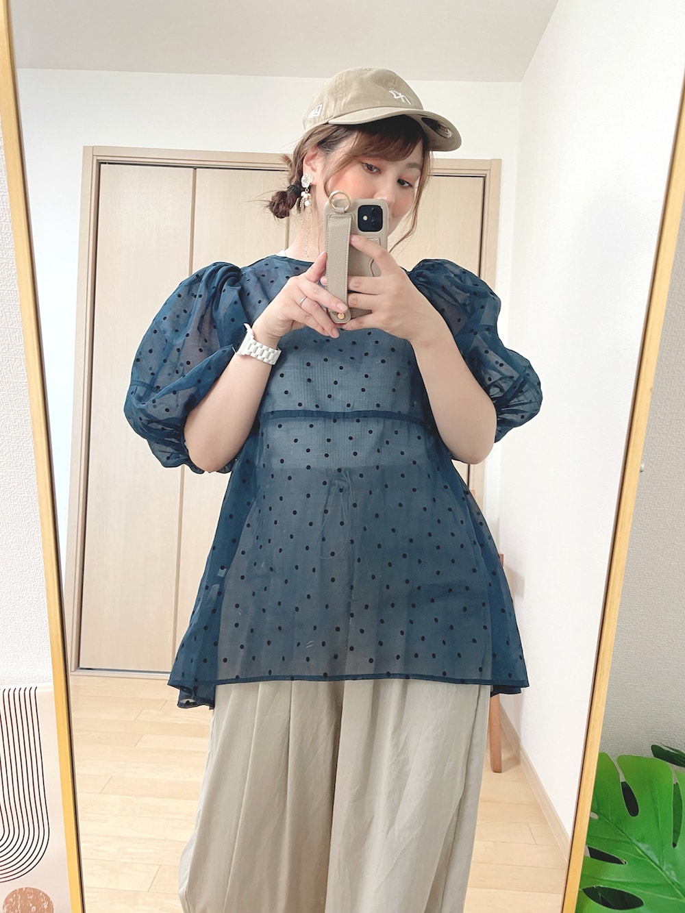 ブルー系のチュニック、ホワイト系のタンクトップ、ベージュ系のパンツを着用したレディースの夏コーディネートの3枚目の写真