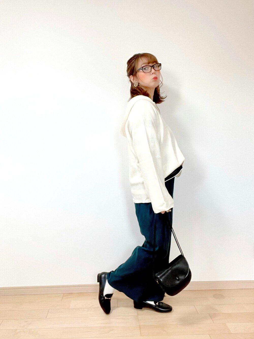 ホワイト系のニット/セーター、ブラック系のTシャツ/カットソー、グリーン系のパンツを着用したレディースの秋コーディネートの2枚目の写真