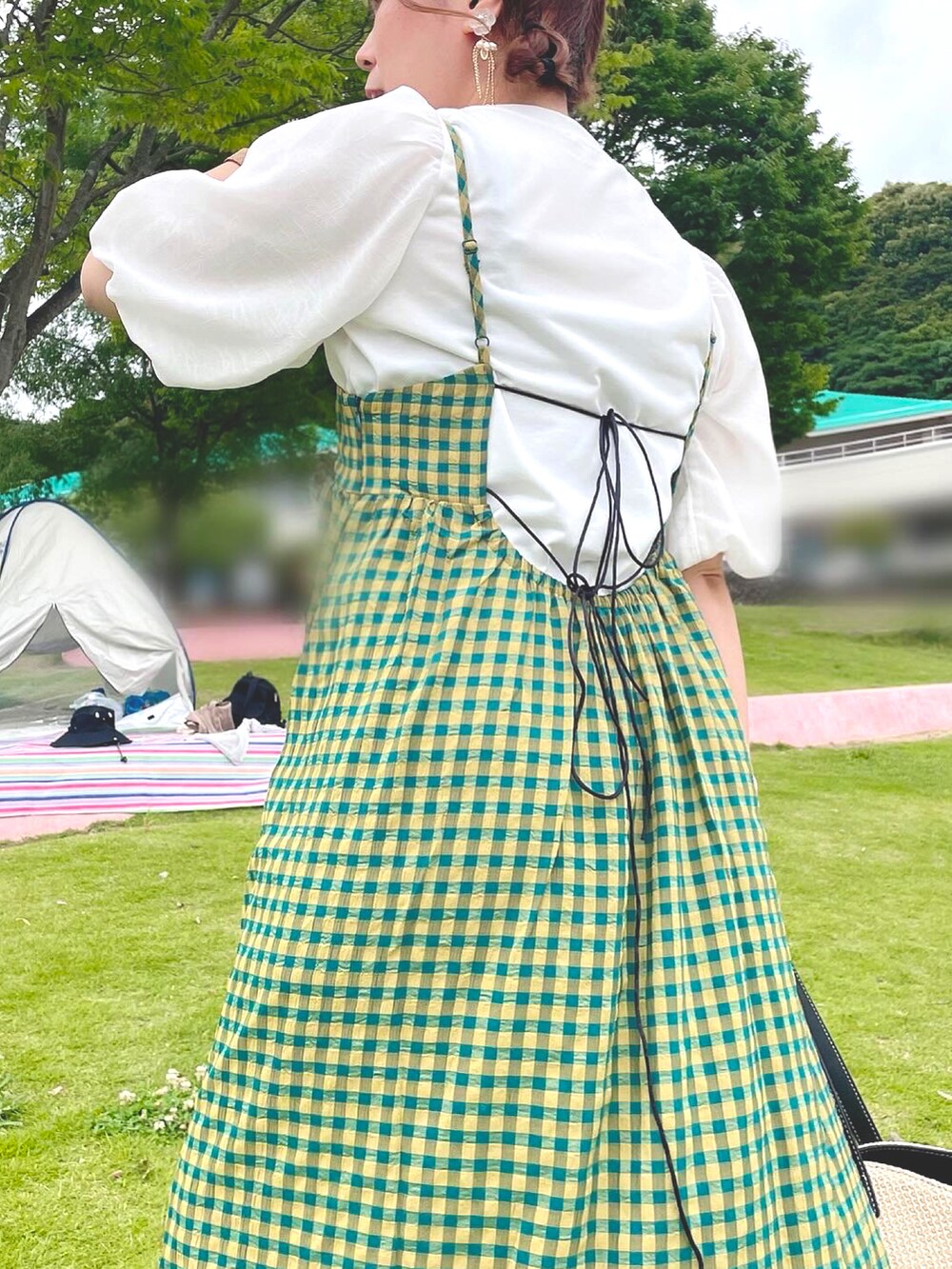 グリーン系のワンピース、ブラック系のサンダル、ブラウン系のバッグを着用したレディースの夏コーディネートの5枚目の写真