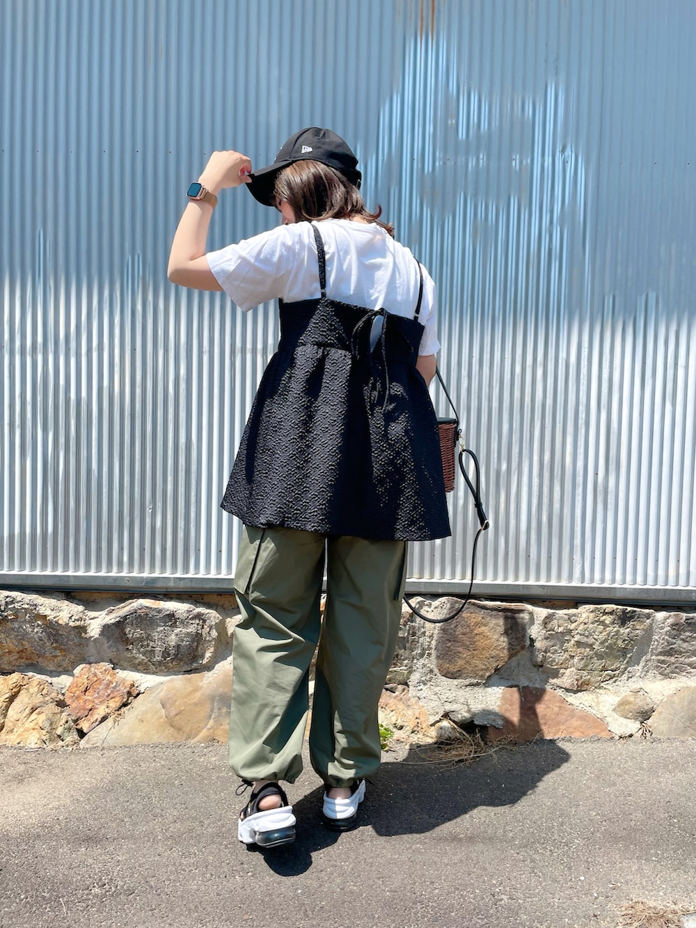 ホワイト系のTシャツ/カットソー、ブラック系のキャミソール、グリーン系のカーゴパンツを着用したレディースの春コーディネートの5枚目の写真