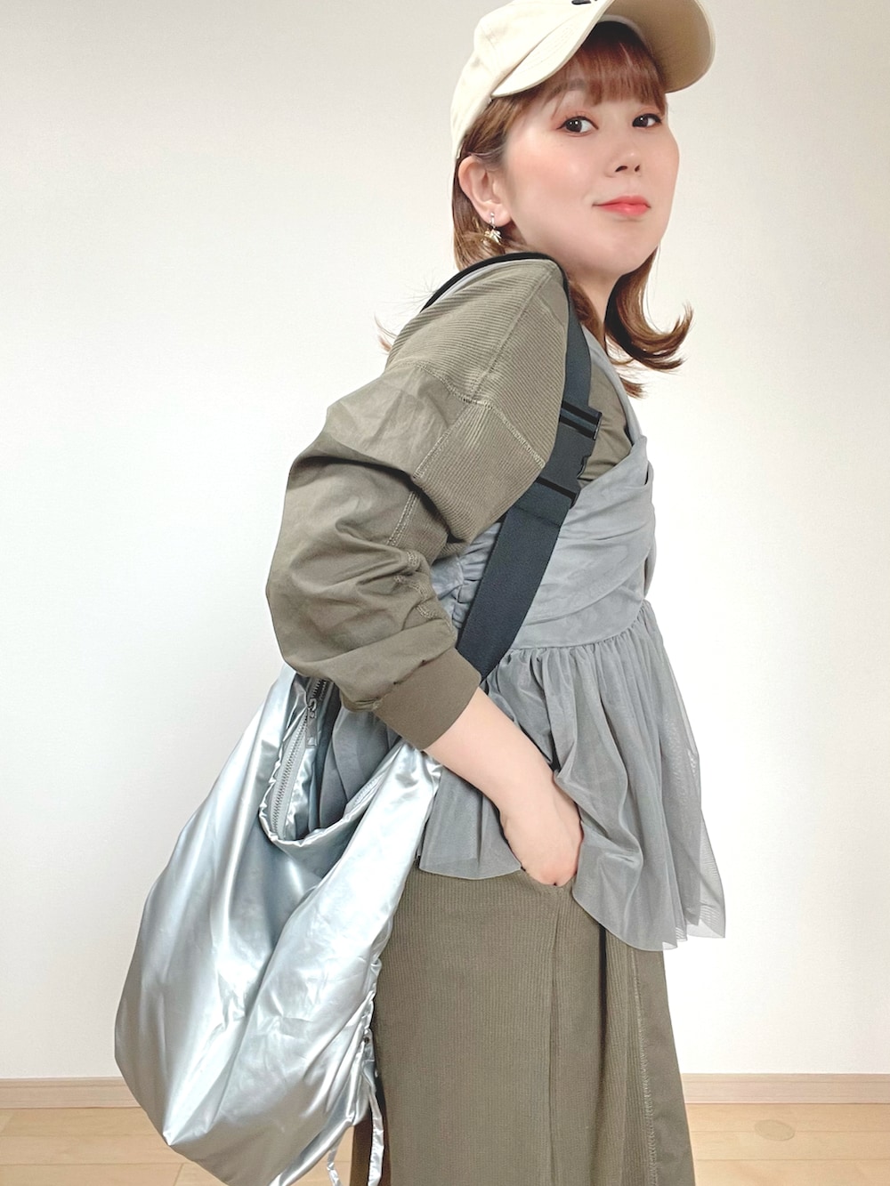 グレー系のキャミソール、グリーン系のワンピース、ブラック系のサンダルを着用したレディースの春コーディネートの5枚目の写真