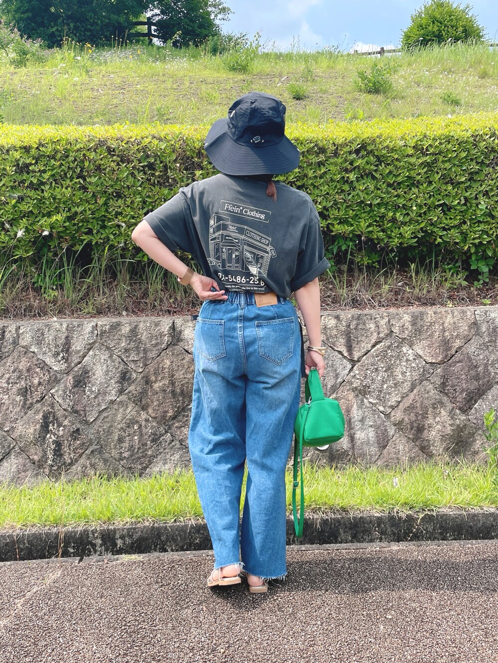 グレー系のTシャツ/カットソー、ブルー系のデニムパンツ、ゴールド系のサンダルを着用したレディースの夏コーディネートの2枚目の写真