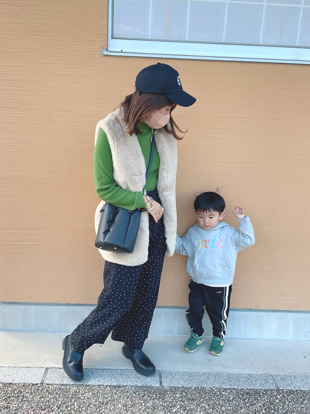 グリーン系のニット/セーター、ホワイト系のベスト、ブラック系のその他パンツを着用したレディースの秋コーディネートの2枚目の写真