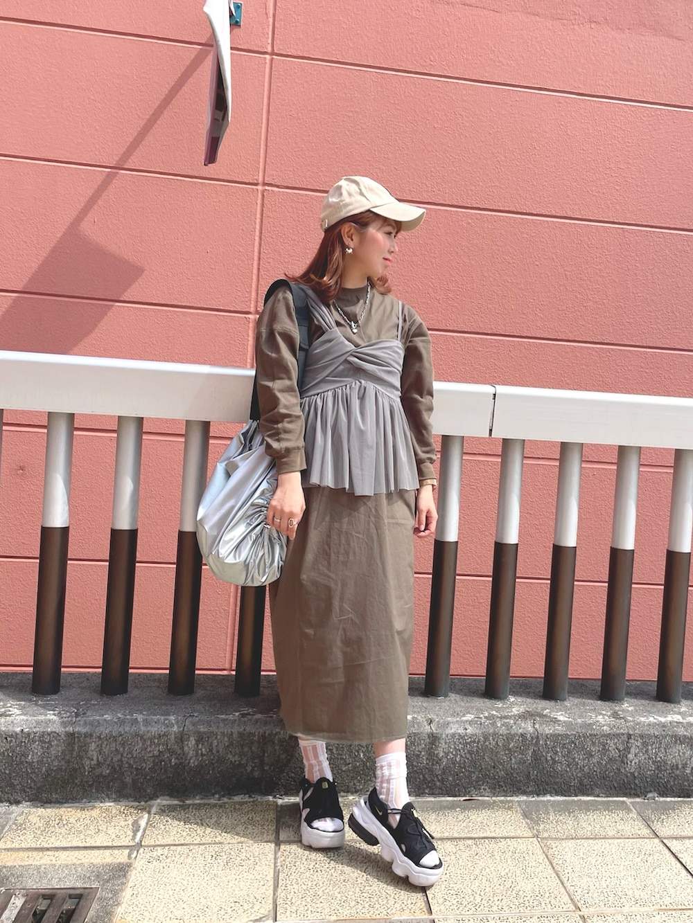 グレー系のキャミソール、グリーン系のワンピース、ブラック系のサンダルを着用したレディースの春コーディネートの2枚目の写真