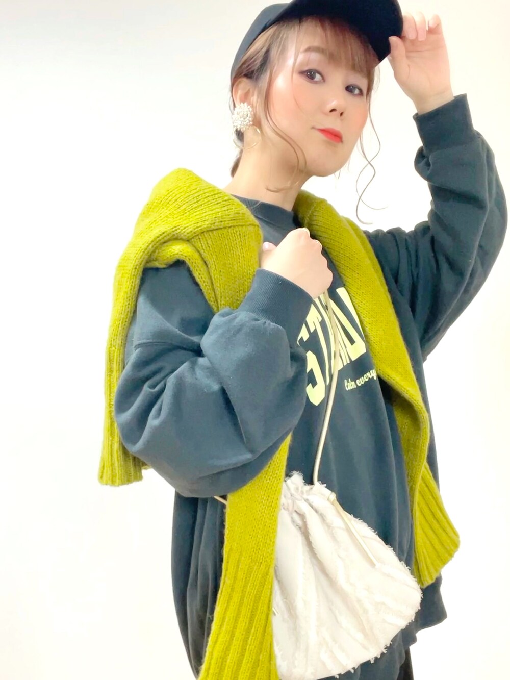 ブラック系のスウェット、グリーン系のニット/セーター、ブラック系のスカートを着用したレディースの冬コーディネートの4枚目の写真