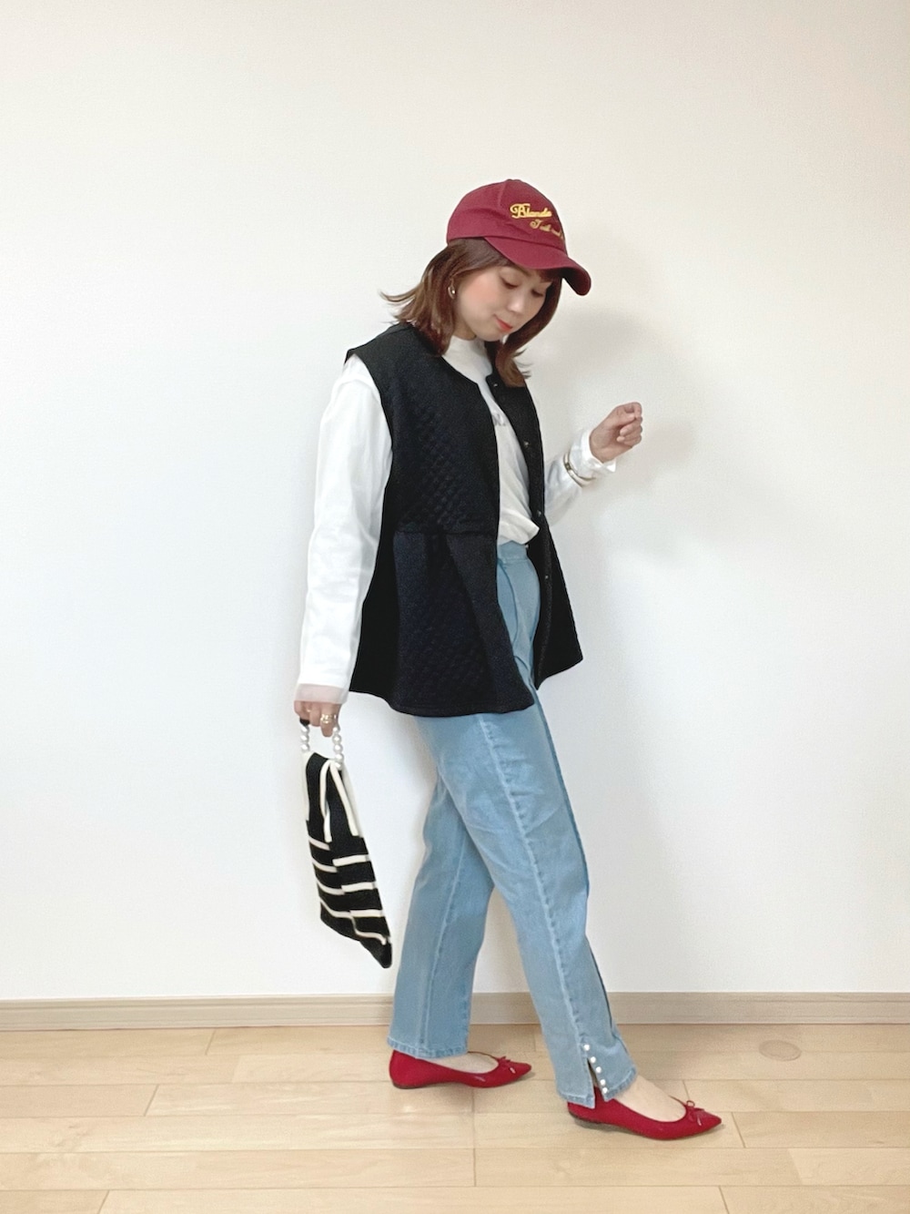 ブラック系のベスト、ブルー系のデニムパンツ、ホワイト系のTシャツ/カットソーを着用したレディースの春コーディネートの3枚目の写真