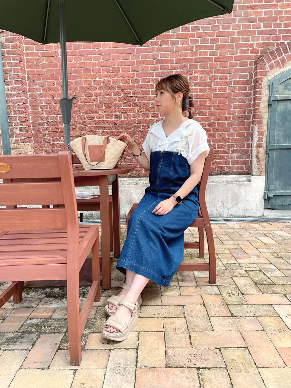 ホワイト系のトップス、ブルー系のオールインワン・サロペット、ブラウン系のタンクトップを着用したレディースの夏コーディネートの3枚目の写真