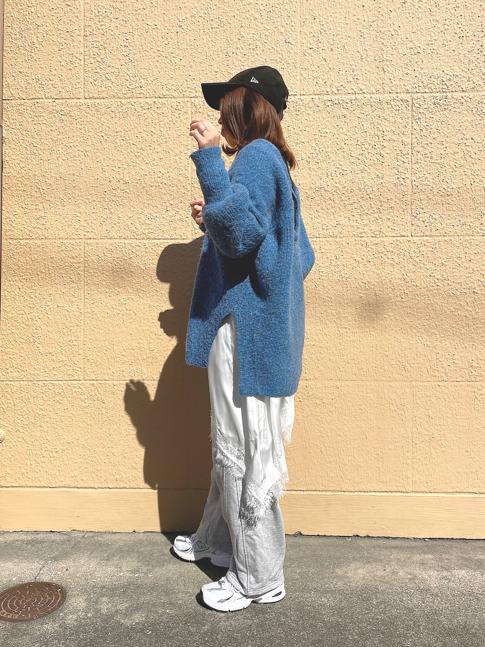 ブルー系のニット/セーター、ホワイト系のキャミソール、グレー系のスウェットパンツを着用したレディースの春コーディネートの4枚目の写真