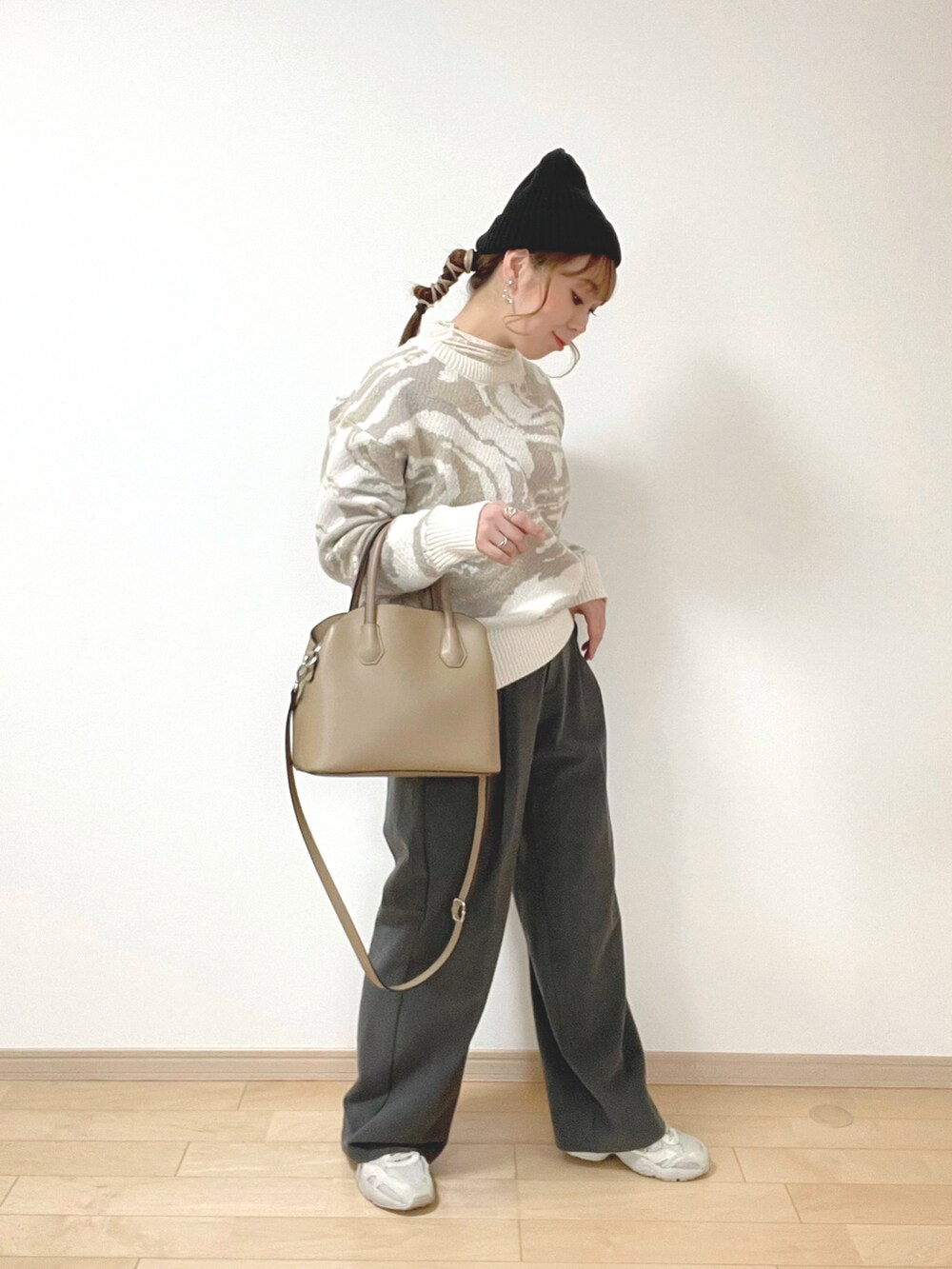 ベージュ系のニット/セーター、ホワイト系のトップス、グレー系のパンツを着用したレディースの冬コーディネートの3枚目の写真
