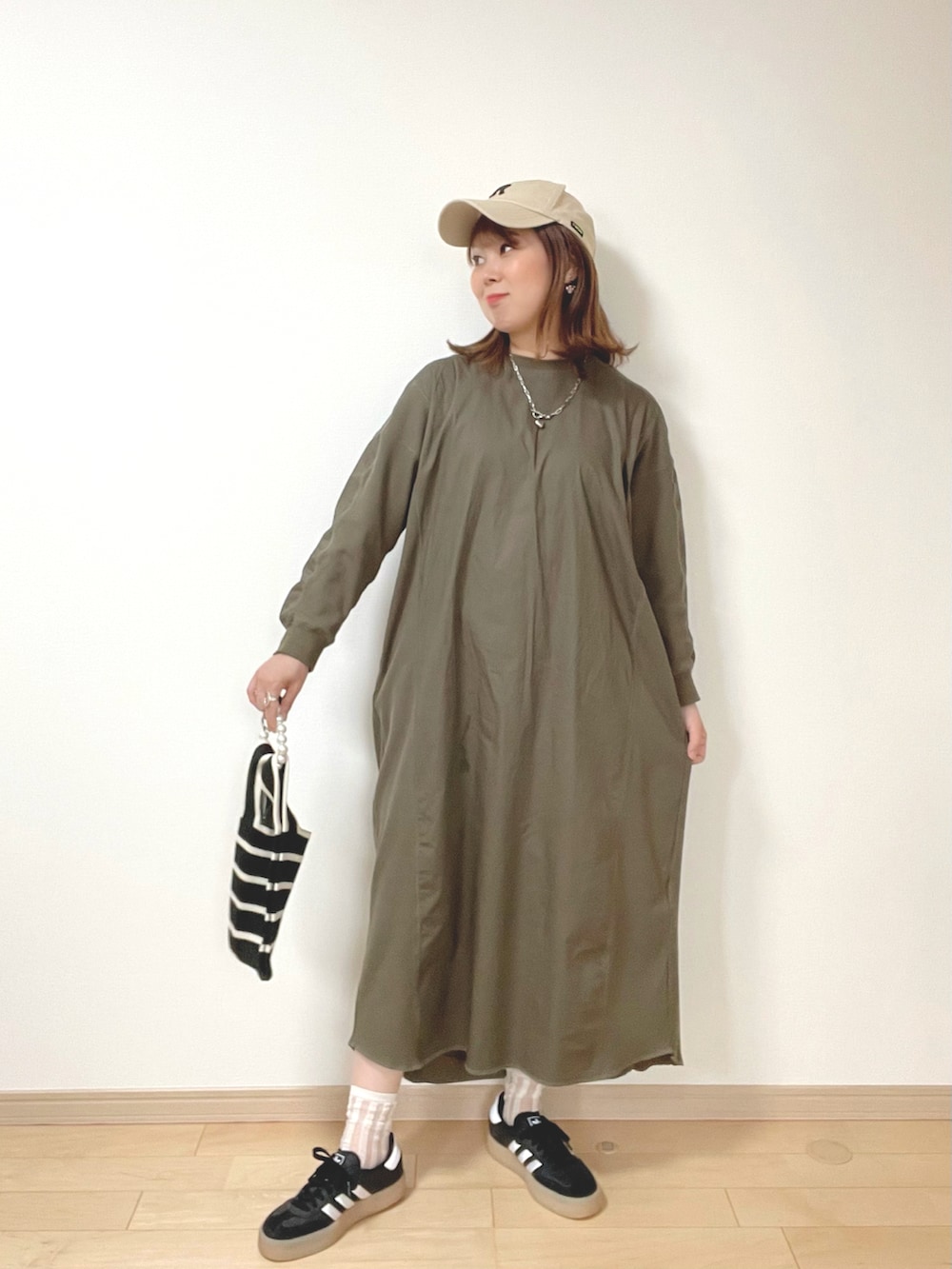 グレー系のキャミソール、グリーン系のワンピース、ブラック系のサンダルを着用したレディースの春コーディネートの3枚目の写真