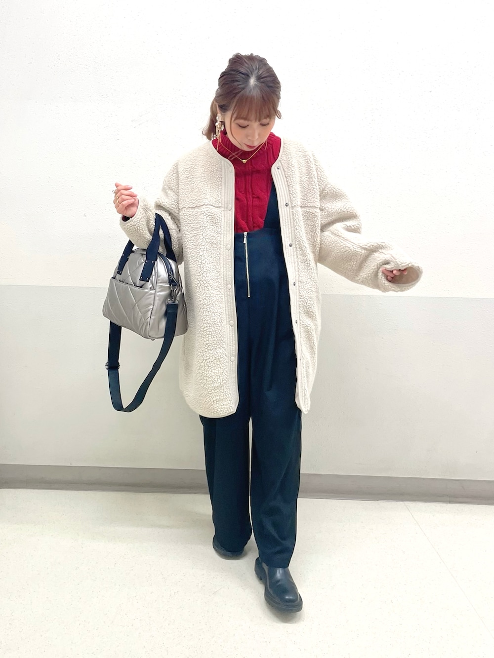 レッド系のニット/セーター、ベージュ系のサロペット/オーバーオール、シルバー系のトートバッグを着用したレディースの冬コーディネートの3枚目の写真