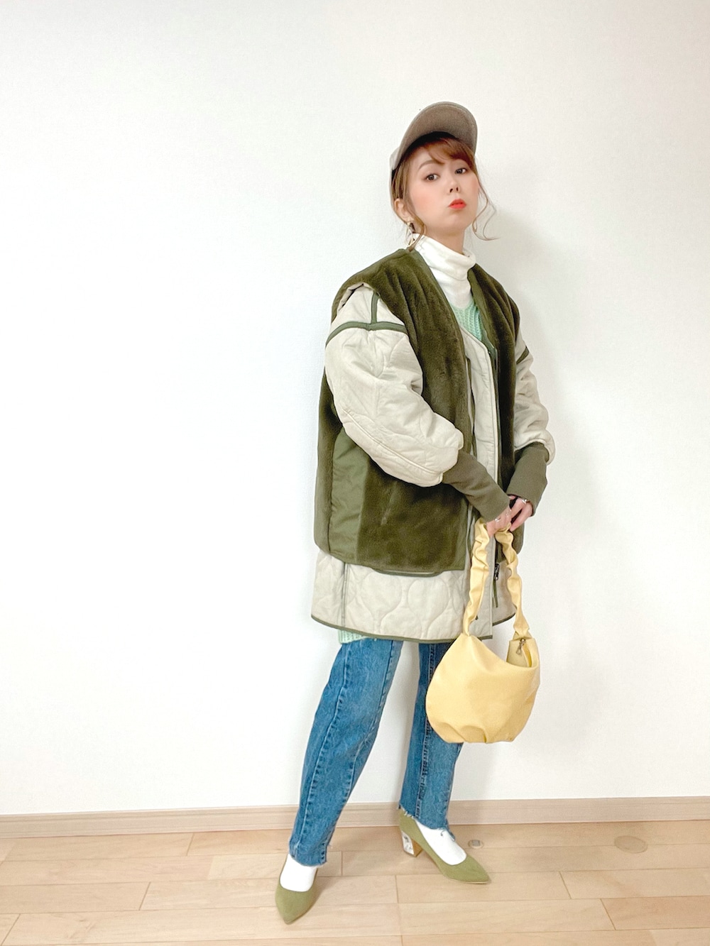 グリーン系のニット/セーター、グリーン系のミリタリージャケット、ホワイト系のTシャツ/カットソーを着用したレディースの冬コーディネートの2枚目の写真