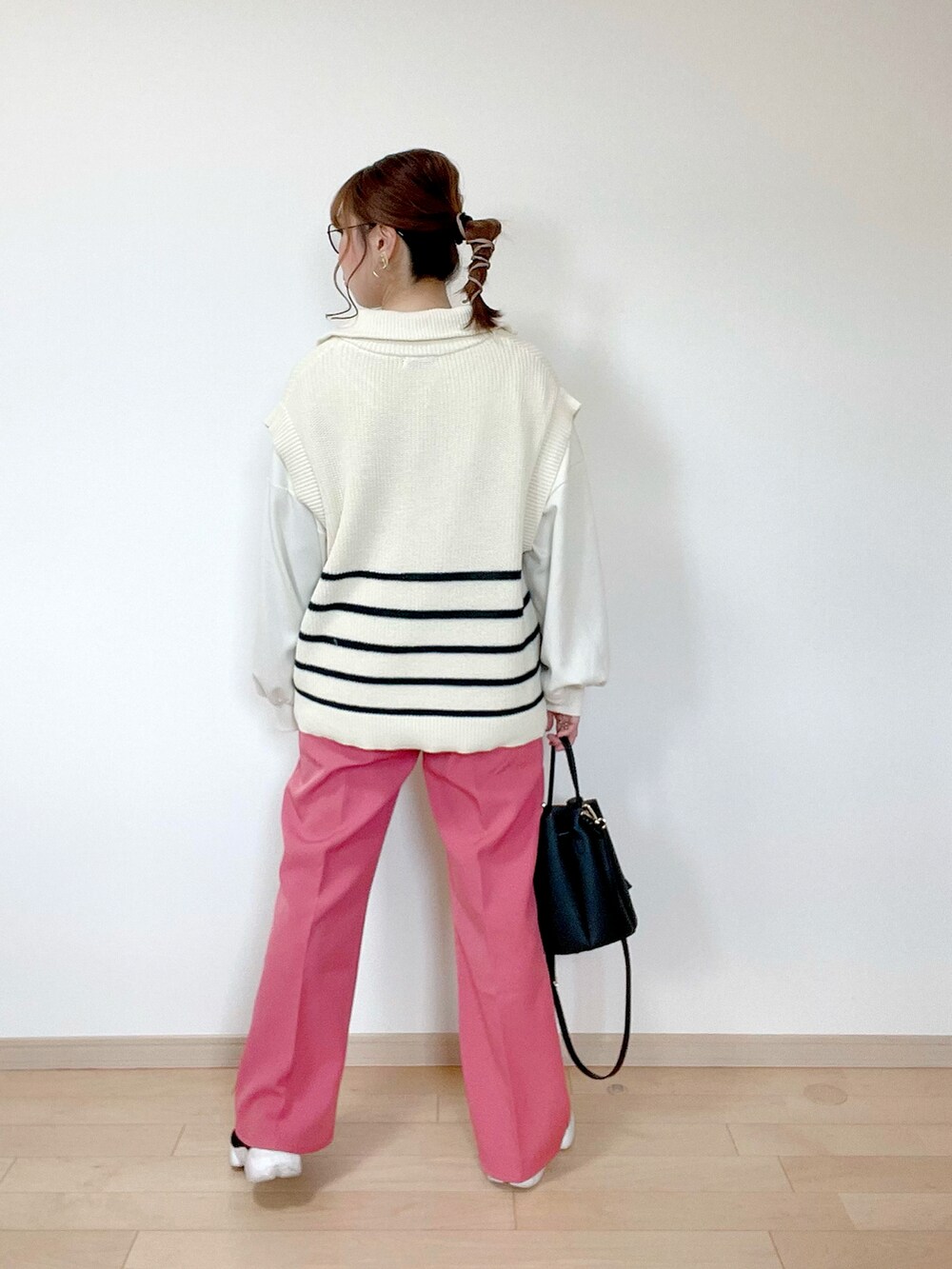 ホワイト系のベスト、ホワイト系のスウェット、ピンク系のスラックスを着用したレディースの春コーディネートの3枚目の写真
