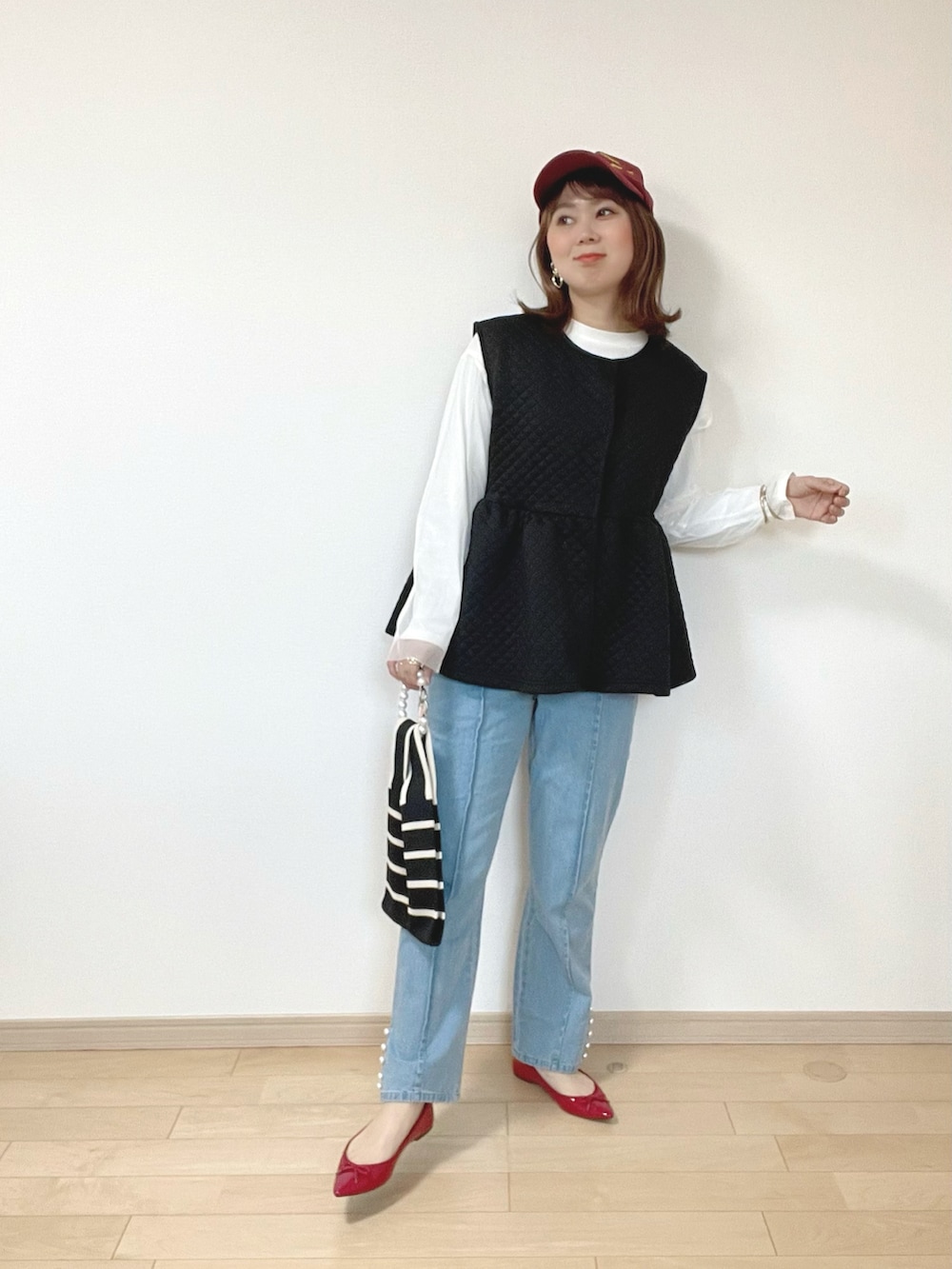 ブラック系のベスト、ブルー系のデニムパンツ、ホワイト系のTシャツ/カットソーを着用したレディースの春コーディネートの4枚目の写真