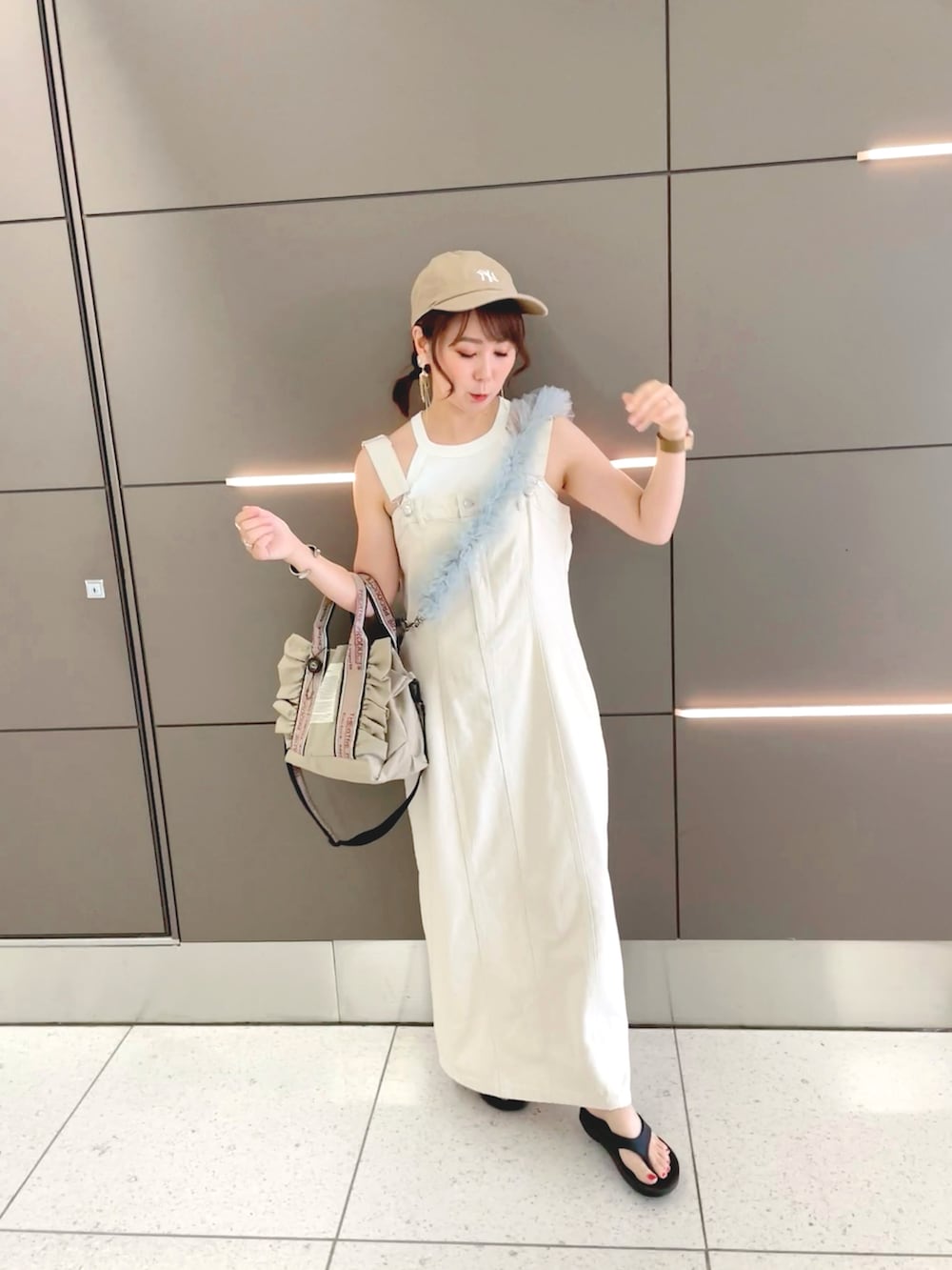 ブラック系のベスト、ホワイト系のタンクトップ、ベージュ系のジャンパースカートを着用したレディースの夏コーディネートの3枚目の写真