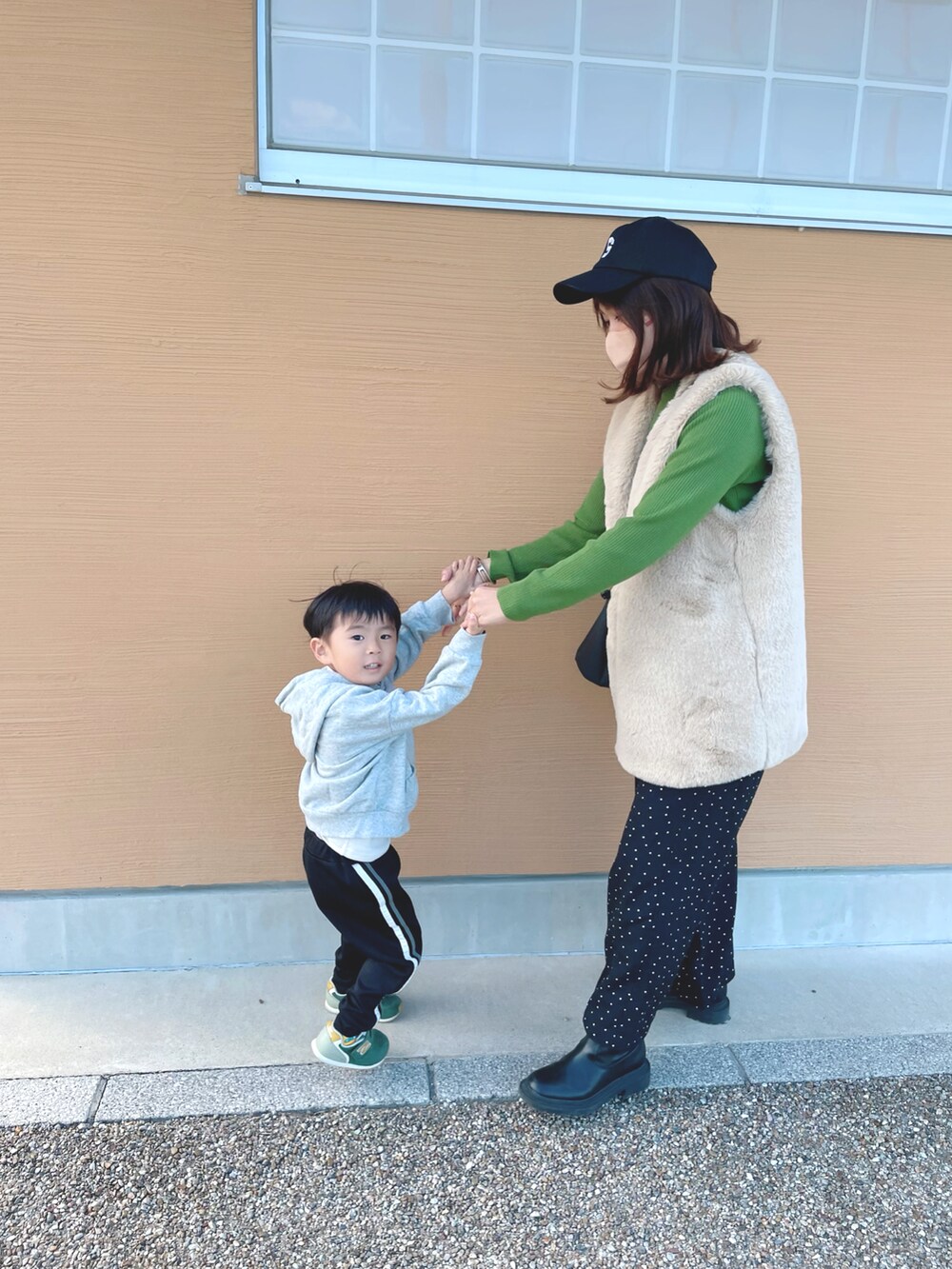 グリーン系のニット/セーター、ホワイト系のベスト、ブラック系のその他パンツを着用したレディースの秋コーディネートの4枚目の写真