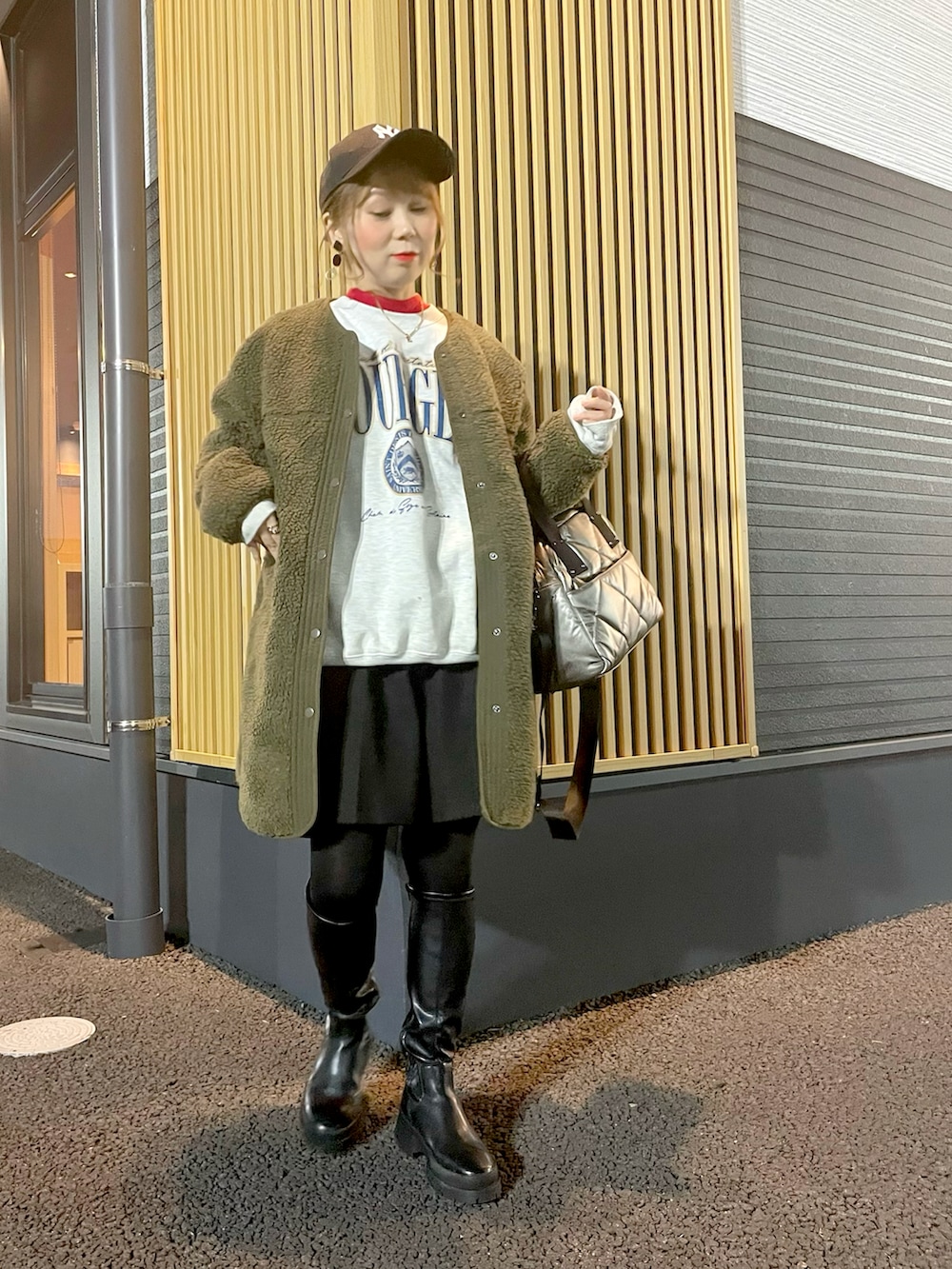 ベージュ系のスウェット、レッド系のニット/セーター、グリーン系のジャケット/アウターを着用したレディースの冬コーディネートの2枚目の写真