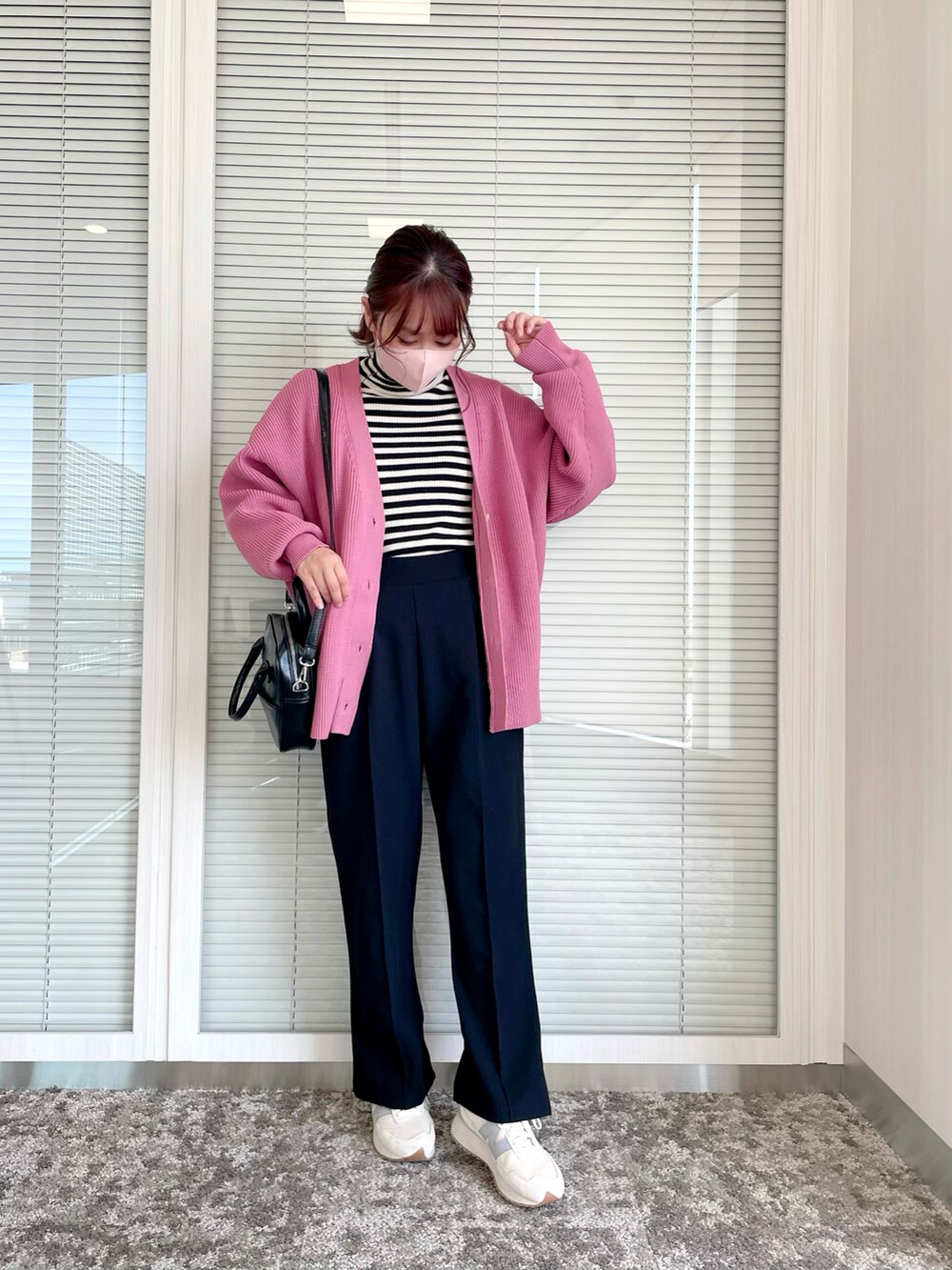 ピンク系のカーディガン/ボレロ、ブラック系のニット/セーター、ブラック系のパンツを着用したレディースの秋コーディネートの2枚目の写真