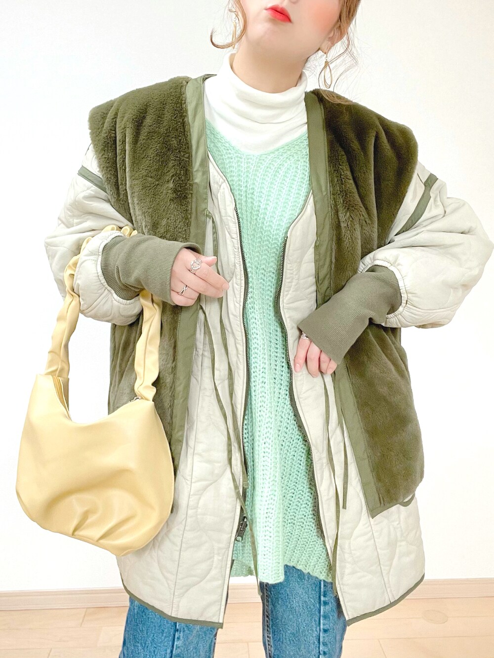 グリーン系のニット/セーター、グリーン系のミリタリージャケット、ホワイト系のTシャツ/カットソーを着用したレディースの冬コーディネートの5枚目の写真