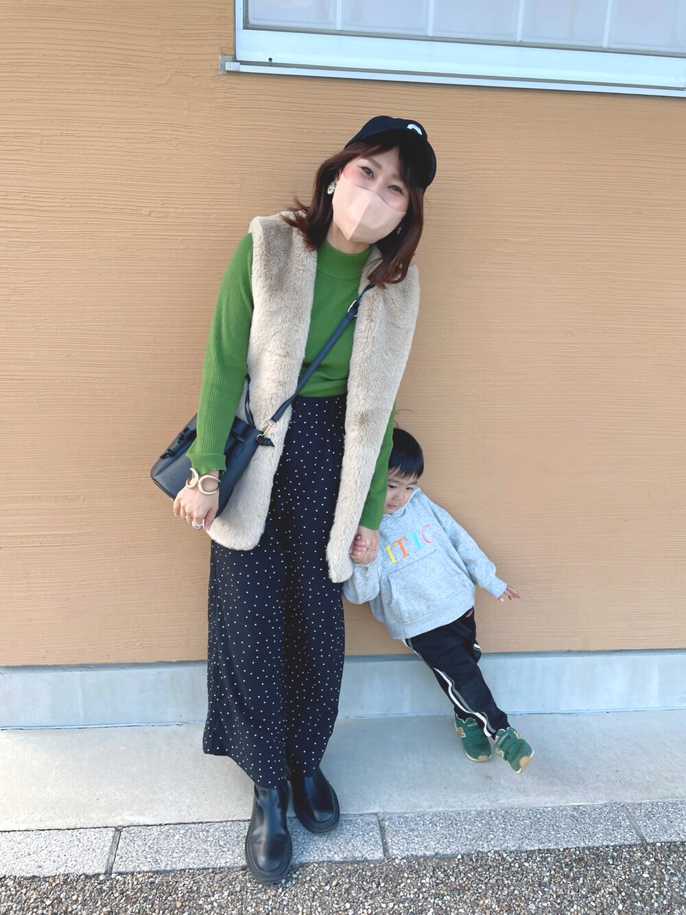 グリーン系のニット/セーター、ホワイト系のベスト、ブラック系のその他パンツを着用したレディースの秋コーディネートの3枚目の写真