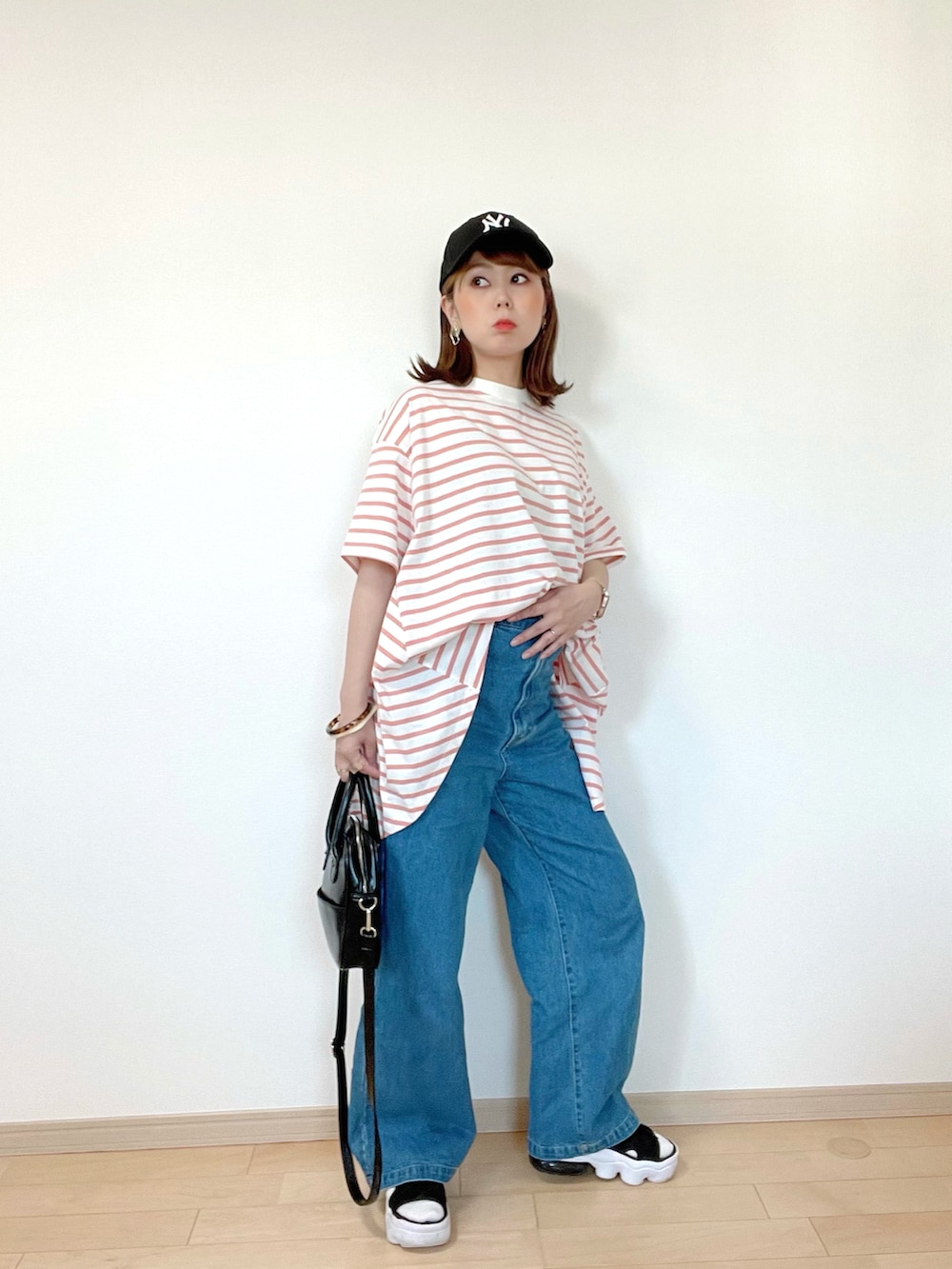 ピンク系のTシャツ/カットソー、ブルー系のデニムパンツ、ブラック系のサンダルを着用したレディースの春コーディネートの5枚目の写真