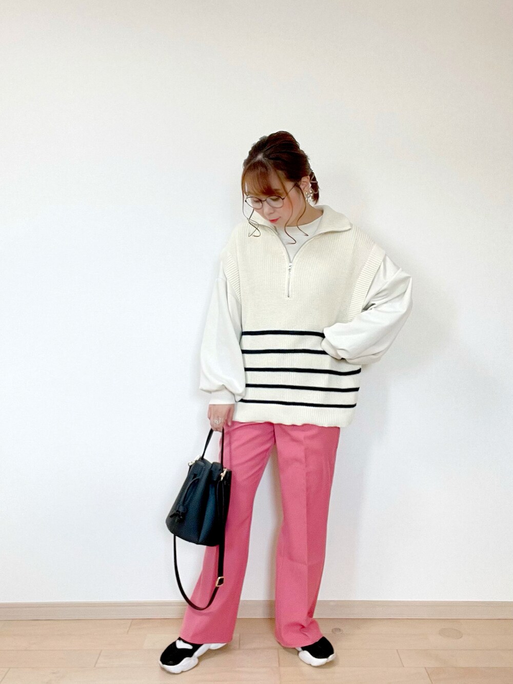 ホワイト系のベスト、ホワイト系のスウェット、ピンク系のスラックスを着用したレディースの春コーディネートの2枚目の写真